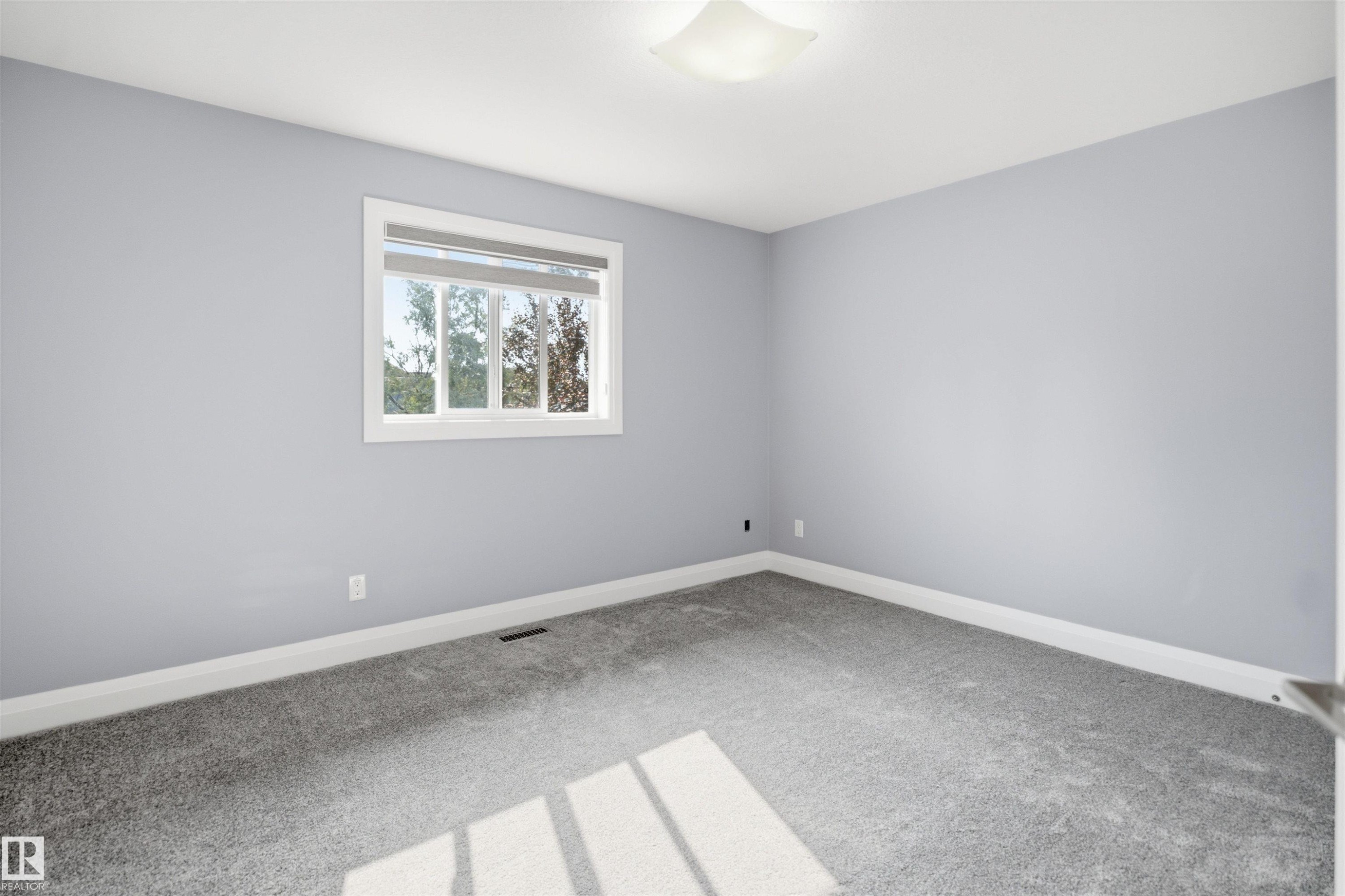 Recessed window with white trim, light gray walls, gray carpet flooring, and a white ceiling-mounted light fixture - 427 Windermere Road Nw, Edmonton, AB - Indoor Photo Showing Other Room