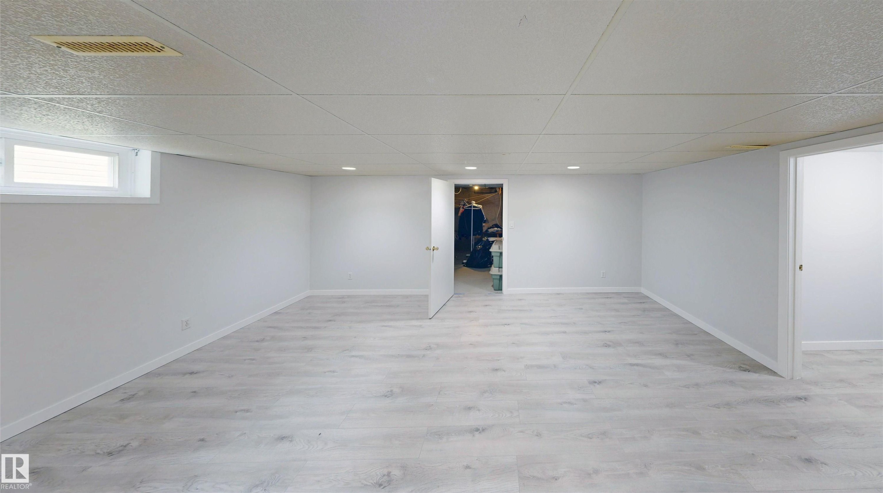 Spacious room featuring light wood-finish flooring, recessed lighting, and a white drop ceiling - 9531 74 Street Nw, Edmonton, AB - Indoor Photo Showing Other Room