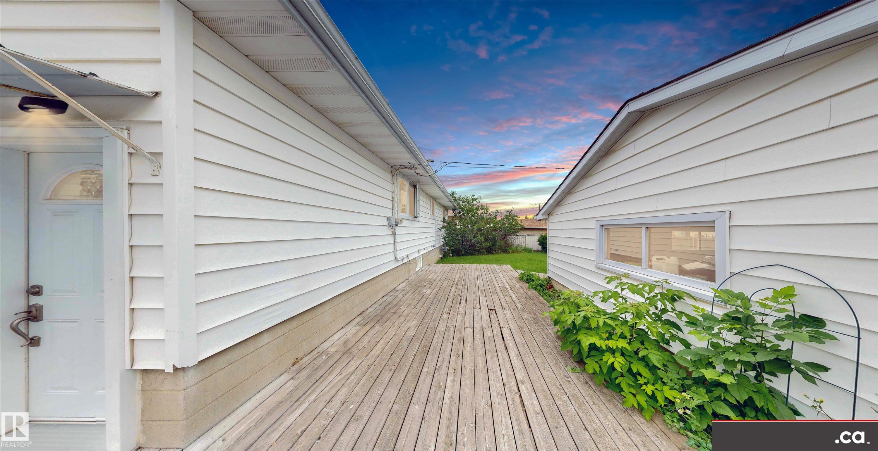 Side decking leading to a white entrance door with an overhang - 9531 74 Street Nw, Edmonton, AB - Outdoor With Exterior
