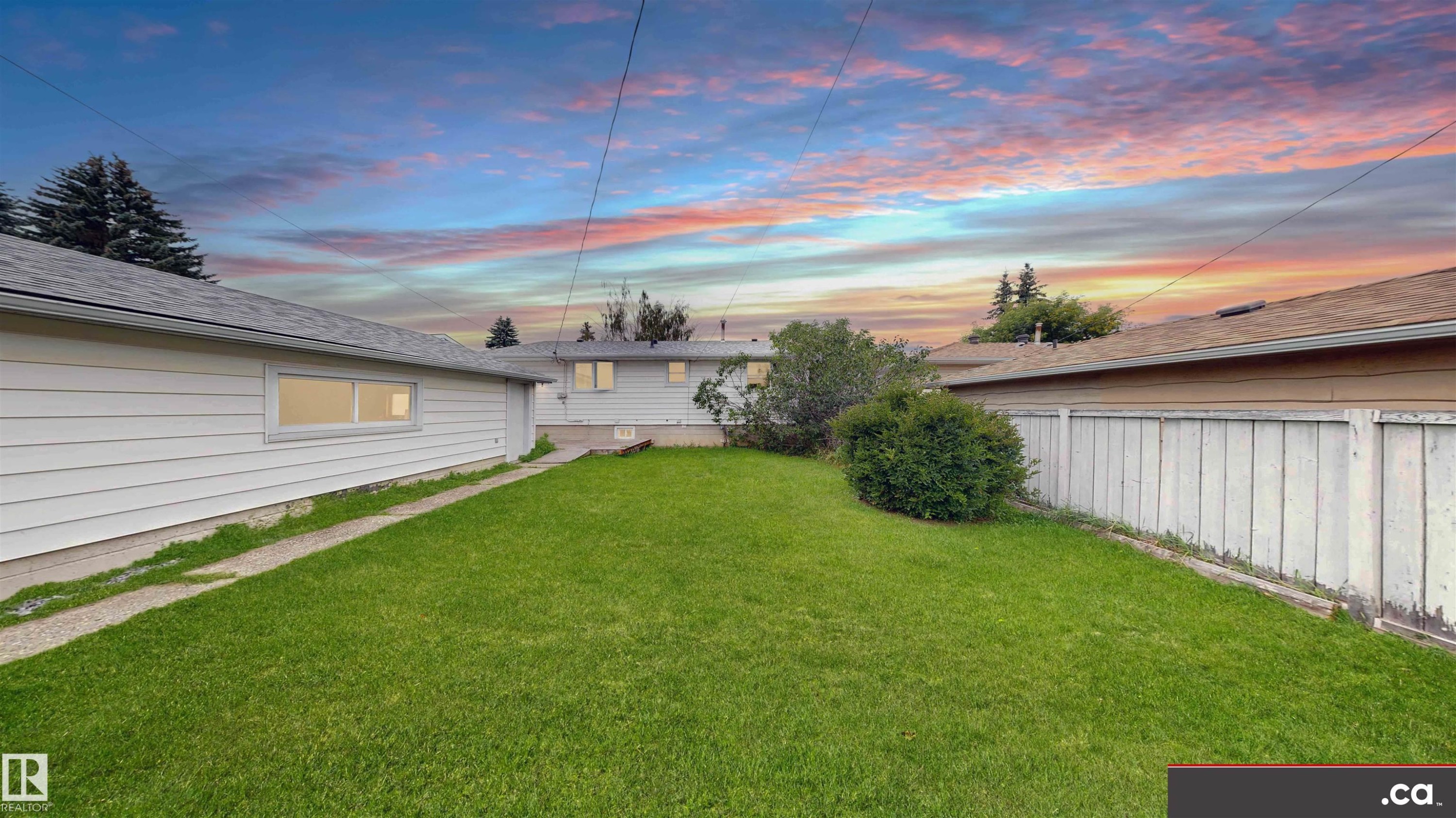 Expansive grassy yard with mature shrubs and trees, concrete pathway, and a privacy fence - 9531 74 Street Nw, Edmonton, AB - Outdoor