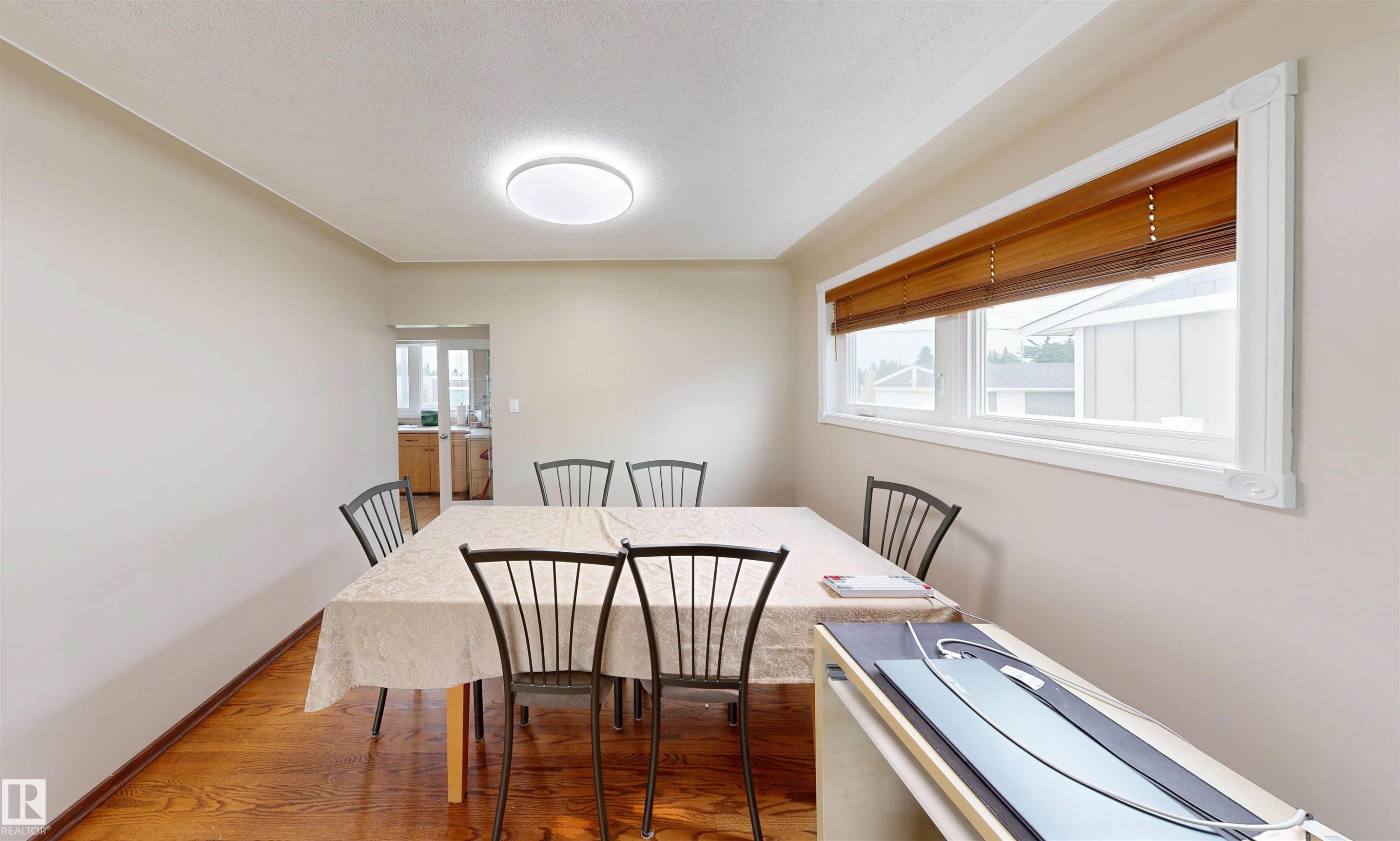 Wood-finish flooring, recessed lighting, and a large window with wood-toned blinds - 9531 74 Street Nw, Edmonton, AB - Indoor Photo Showing Dining Room