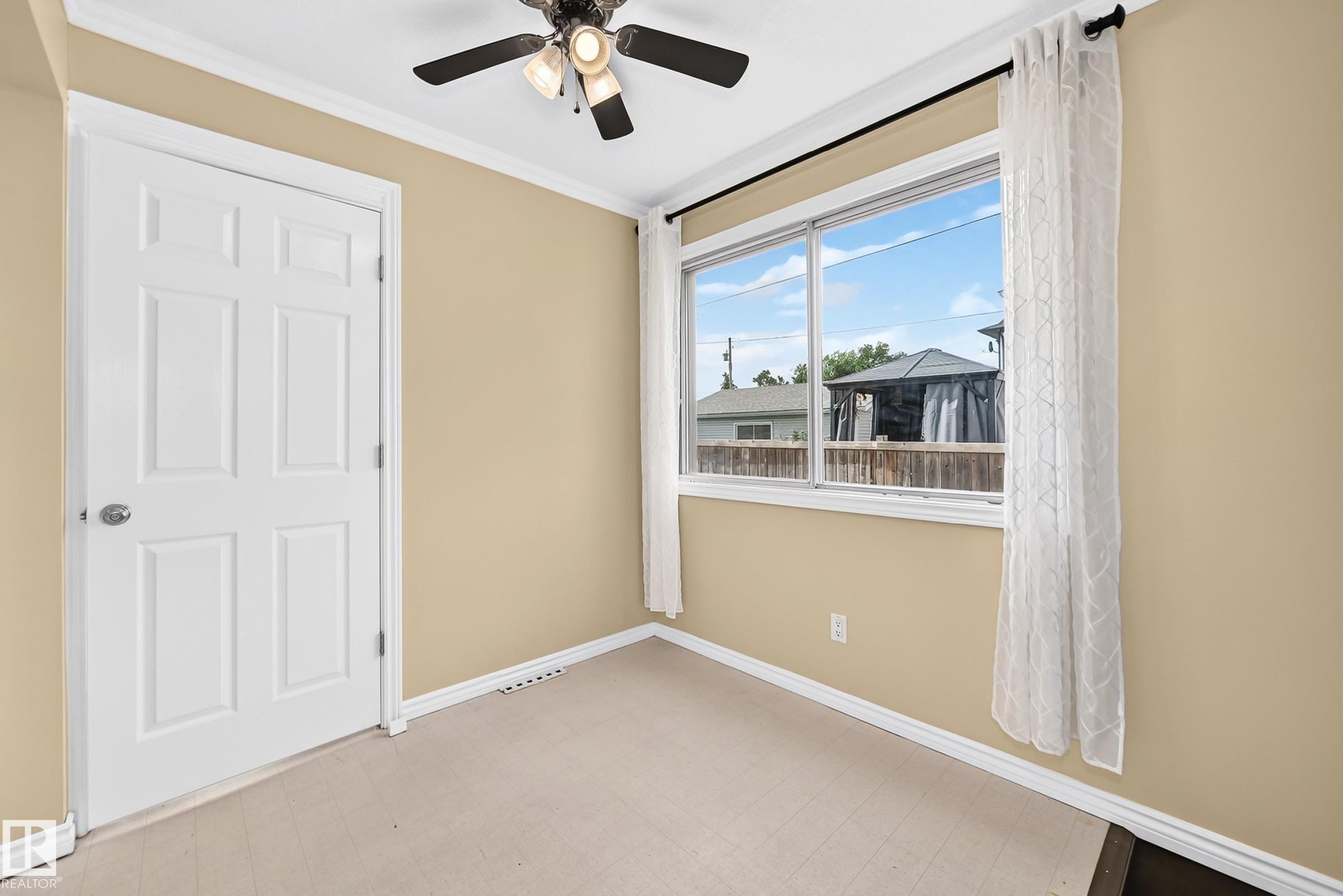 Neutral wall paint, white trim, and a ceiling fan with integrated lighting - 50 Rocque, Fort Saskatchewan, AB - Indoor Photo Showing Other Room