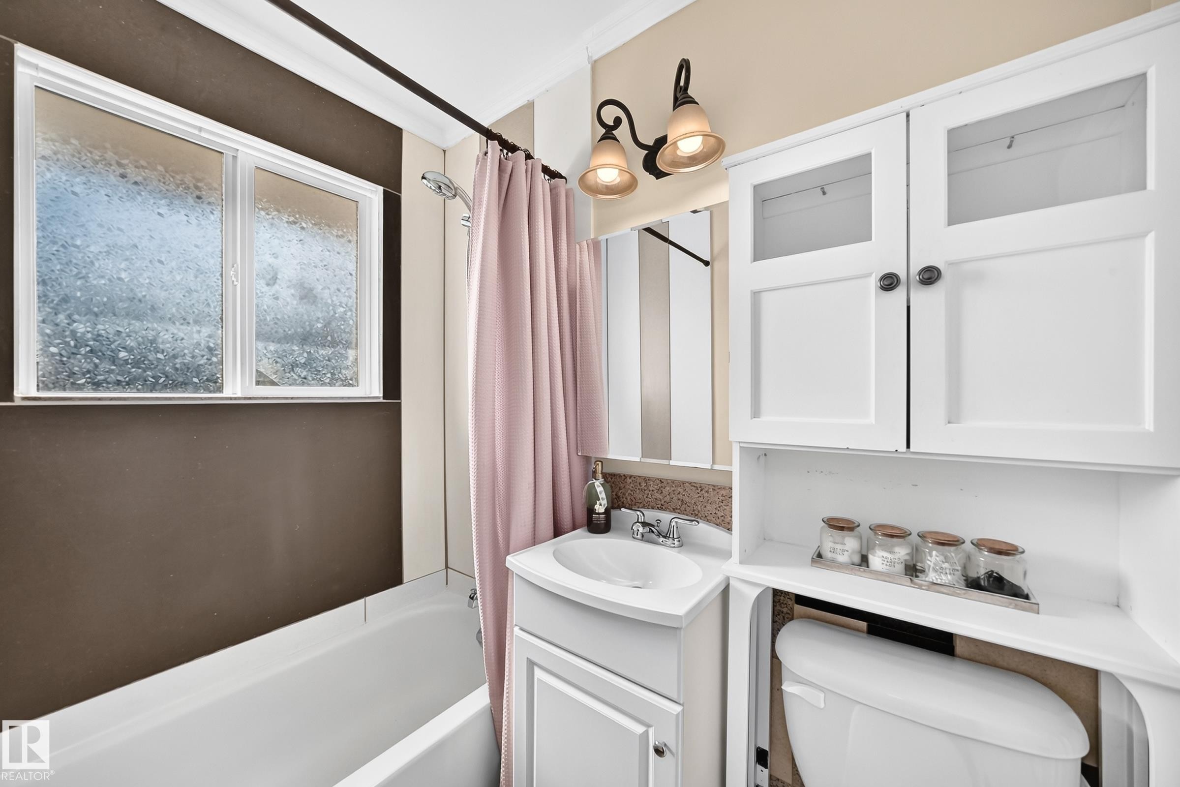 White vanity with integrated sink, overhead wall-mounted lighting, and built-in storage cabinetry - 50 Rocque, Fort Saskatchewan, AB - Indoor Photo Showing Bathroom