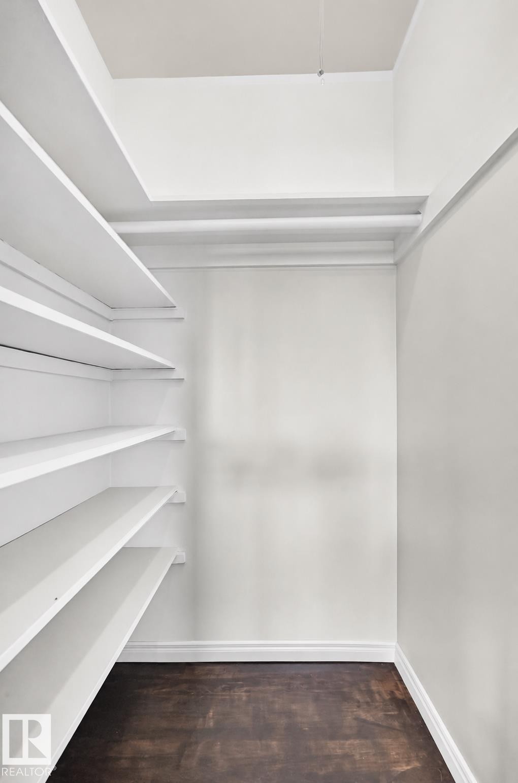 Built-in shelving, dark wood-finish flooring, and white painted walls - 50 Rocque, Fort Saskatchewan, AB - Indoor With Storage
