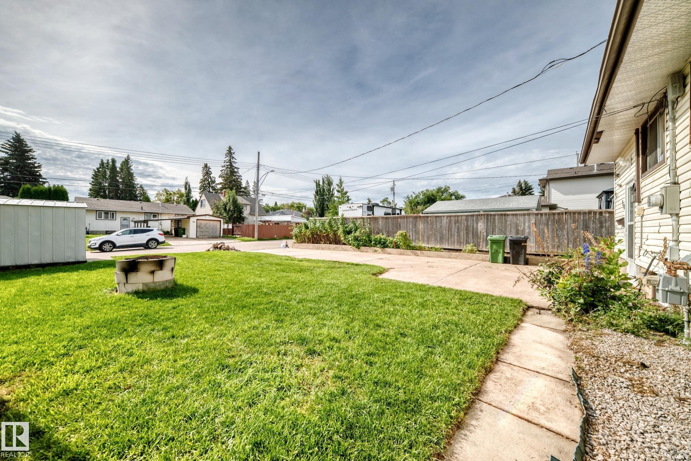 Expansive grassy yard with concrete pathway and mature perimeter fencing - 50 Rocque, Fort Saskatchewan, AB - Outdoor