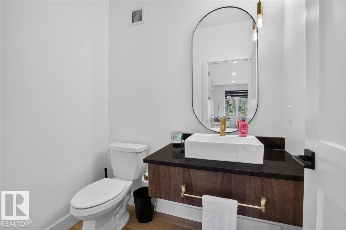 Floating vanity with a rectangular vessel sink, dark countertop, and gold-tone faucet - 94 Harvest Crescent, Ardrossan, AB - Indoor Photo Showing Bathroom