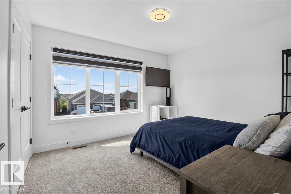 Bright room featuring a multi-pane window, wall-to-wall carpeting, and a flush-mount ceiling light fixture - 94 Harvest Crescent, Ardrossan, AB - Indoor Photo Showing Bedroom