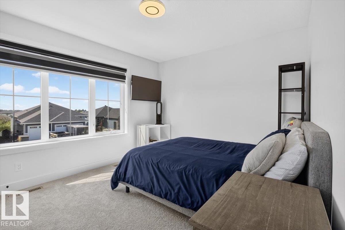 Recessed lighting, large multi-pane window, wall-mounted television, and carpeted flooring - 94 Harvest Crescent, Ardrossan, AB - Indoor Photo Showing Bedroom
