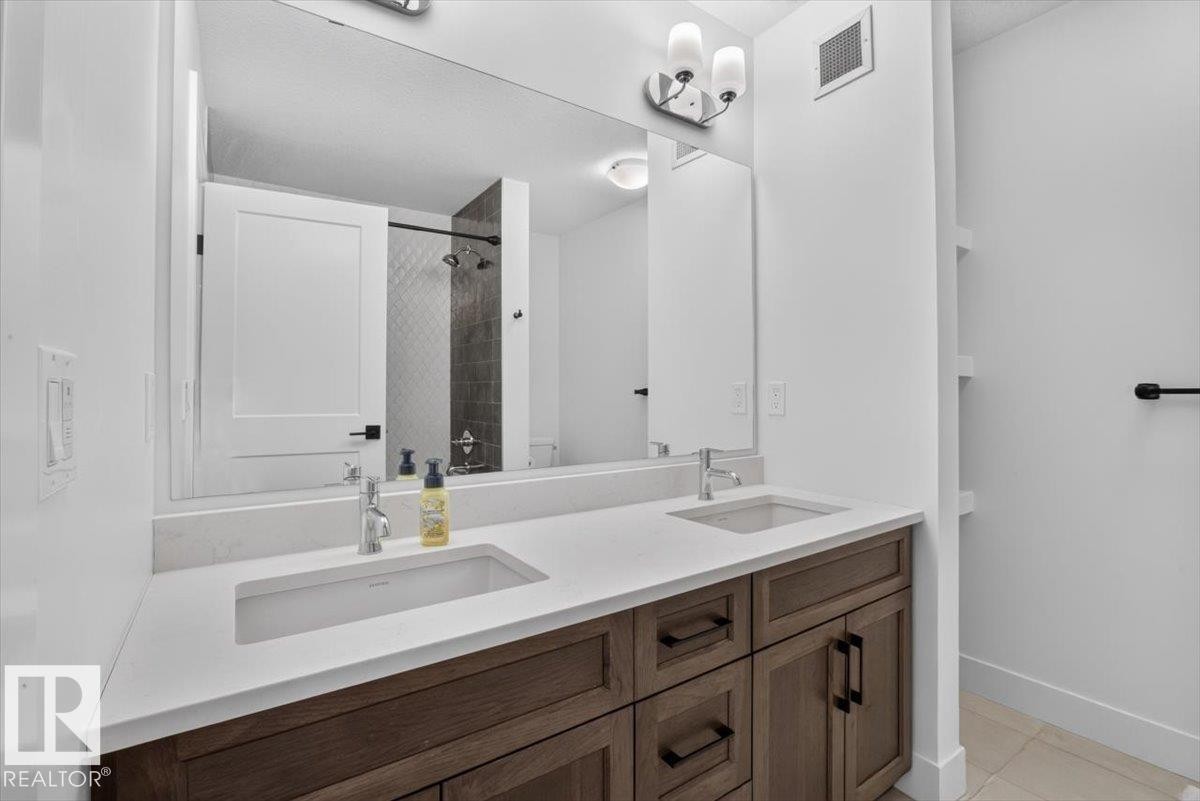 Double vanity with quartz countertop, undermount sinks, and wood-finish cabinetry - 94 Harvest Crescent, Ardrossan, AB - Indoor Photo Showing Bathroom