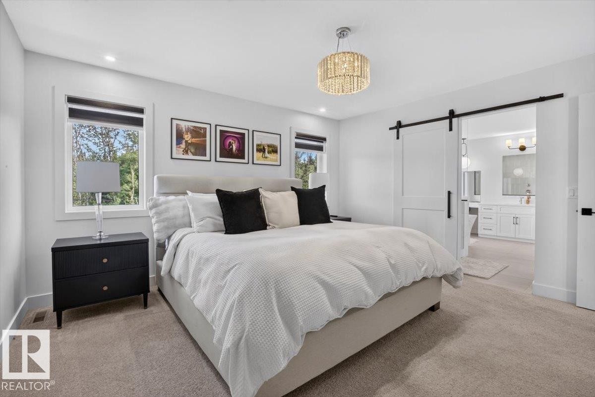 Recessed lighting and a crystal chandelier illuminate the space - 94 Harvest Crescent, Ardrossan, AB - Indoor Photo Showing Bedroom