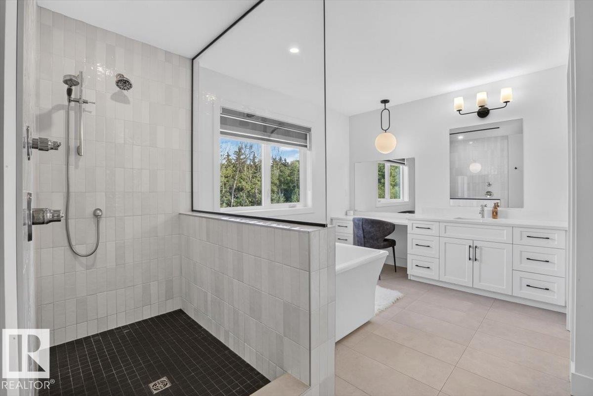 Spacious bath featuring a walk-in shower with light-toned rectangular tile, dark square tile flooring, and dual shower heads - 94 Harvest Crescent, Ardrossan, AB - Indoor Photo Showing Bathroom