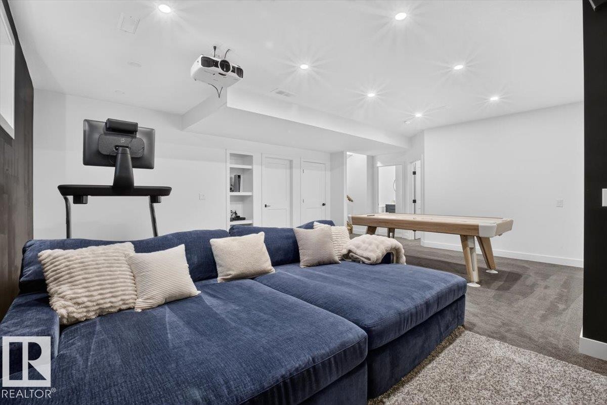 Recessed lighting, wood-finish flooring, built-in shelving, white trim, and a ceiling-mounted projector - 94 Harvest Crescent, Ardrossan, AB - Indoor Photo Showing Bedroom