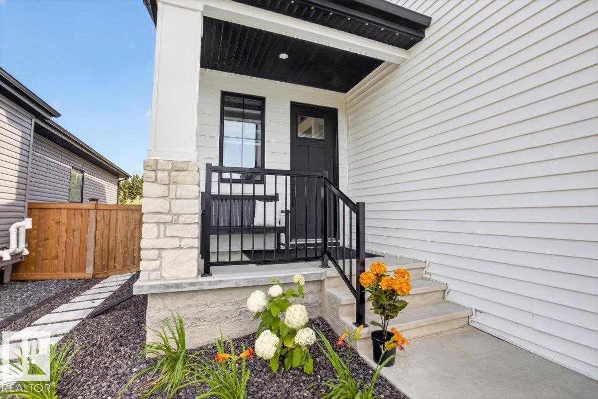 White horizontal siding with stone veneer accents - 94 Harvest Crescent, Ardrossan, AB - Outdoor With Deck Patio Veranda With Exterior