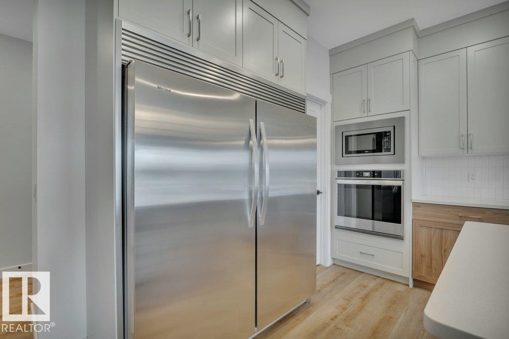 With side-by-side fridge/freezer combo - 5329 Lark Landing Nw, Edmonton, AB - Indoor Photo Showing Kitchen