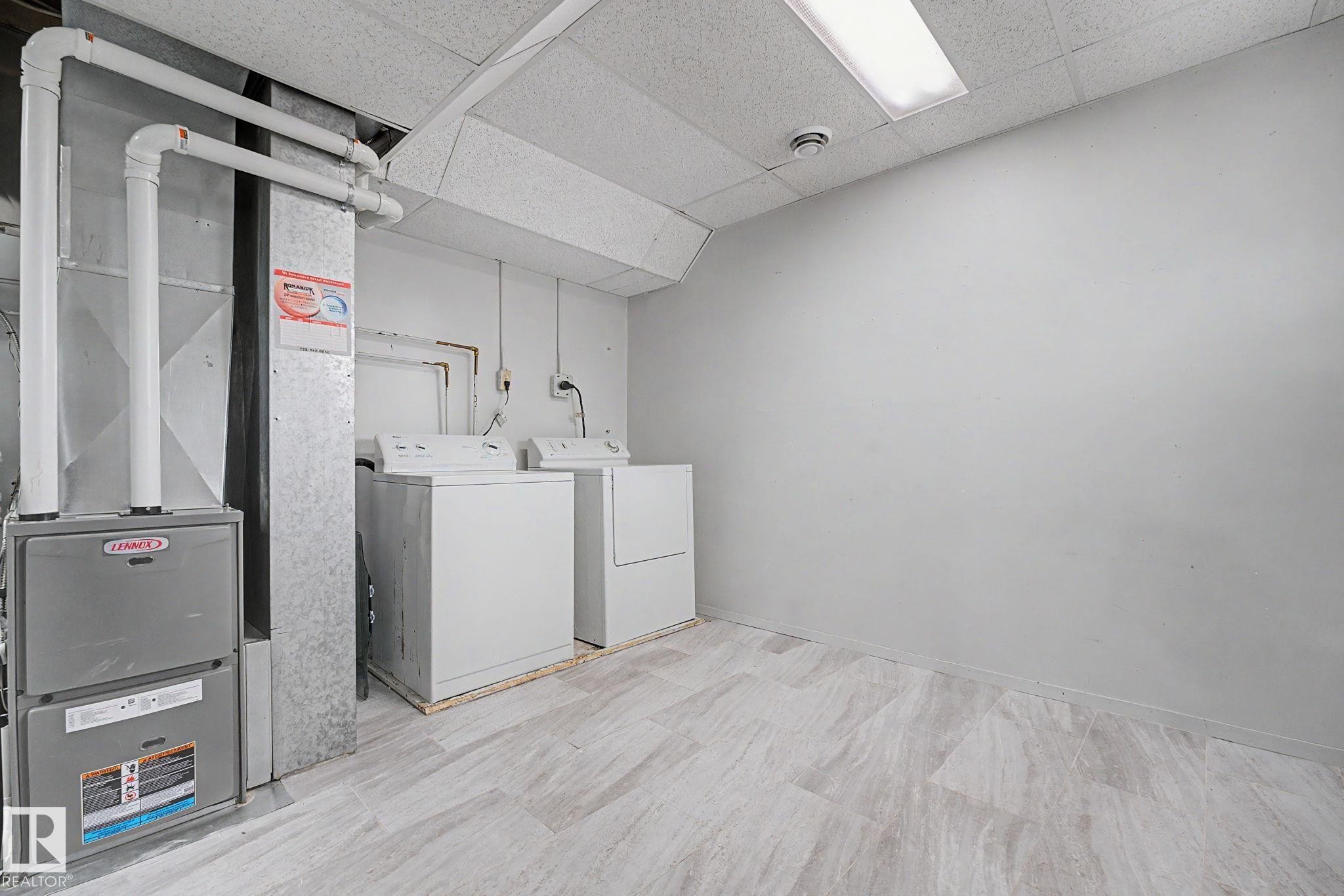 Utility area featuring a furnace system, water heater, and side-by-side washer and dryer units - 1096 Knottwood Road Nw, Edmonton, AB - Indoor Photo Showing Laundry Room