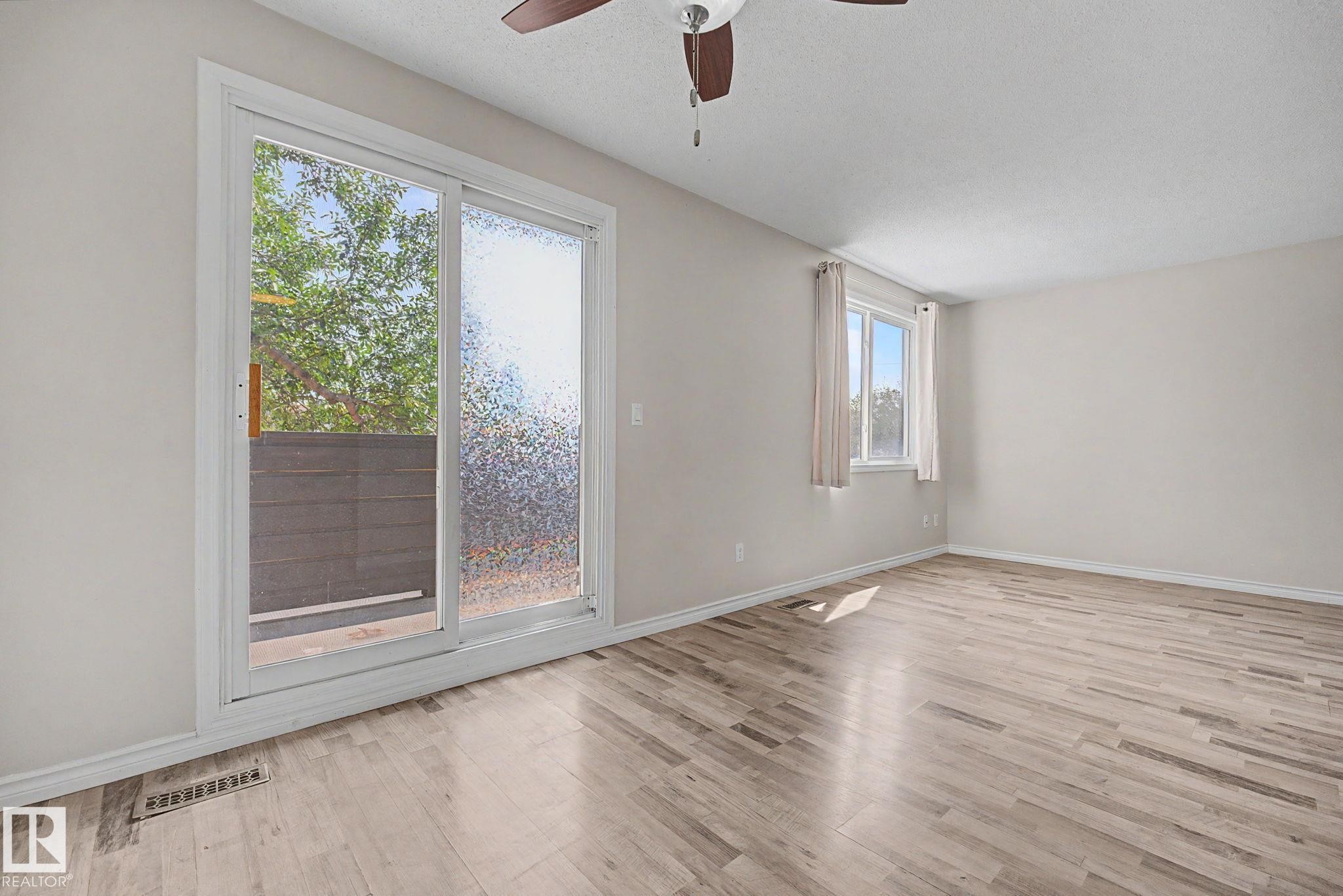 Spacious room featuring wood-finish flooring and light-toned walls - 1096 Knottwood Road Nw, Edmonton, AB - Indoor Photo Showing Other Room