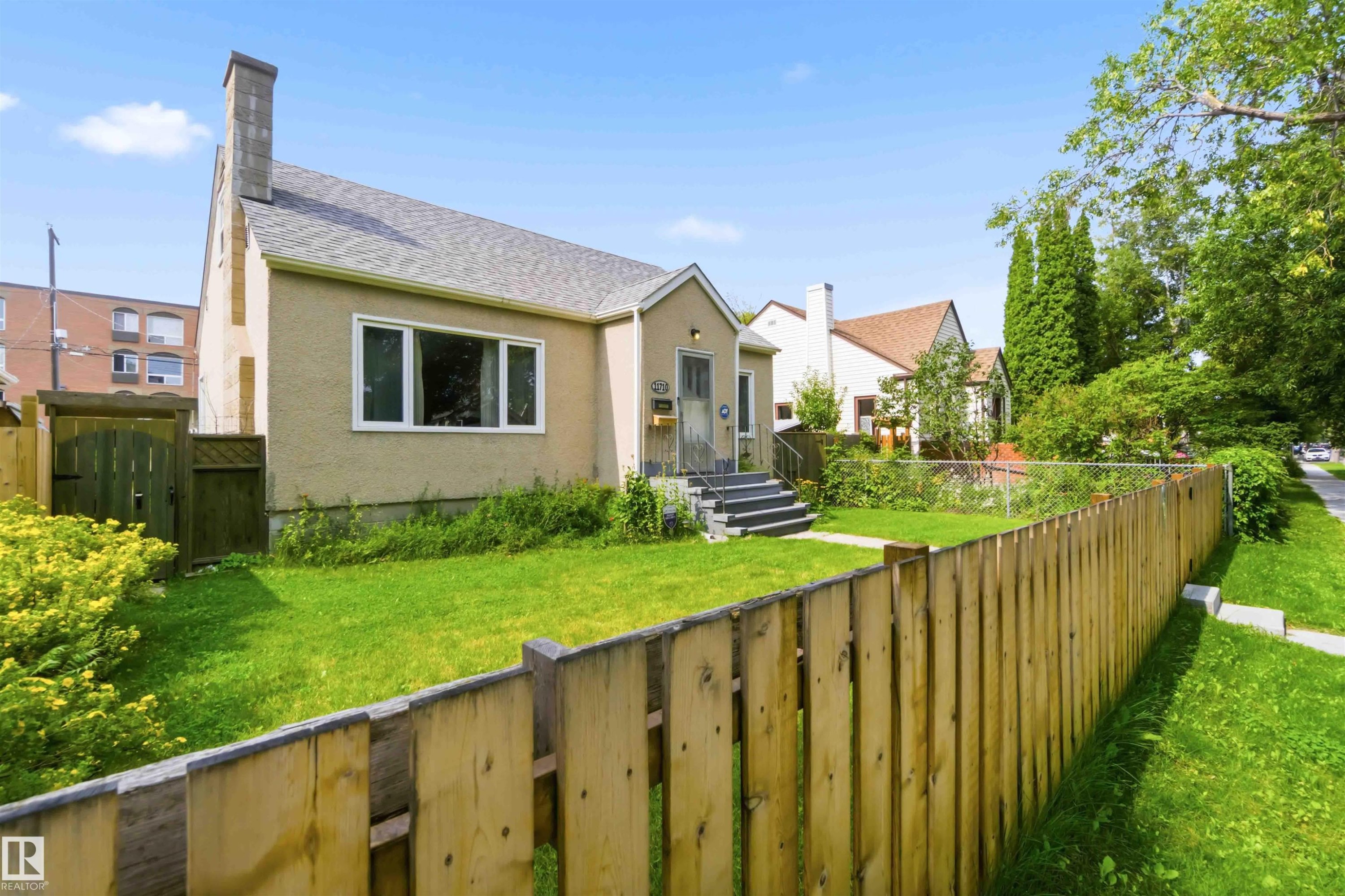 Stucco exterior residence with a gabled roof and prominent chimney - 11710 94 Street Nw, Edmonton, AB - Outdoor