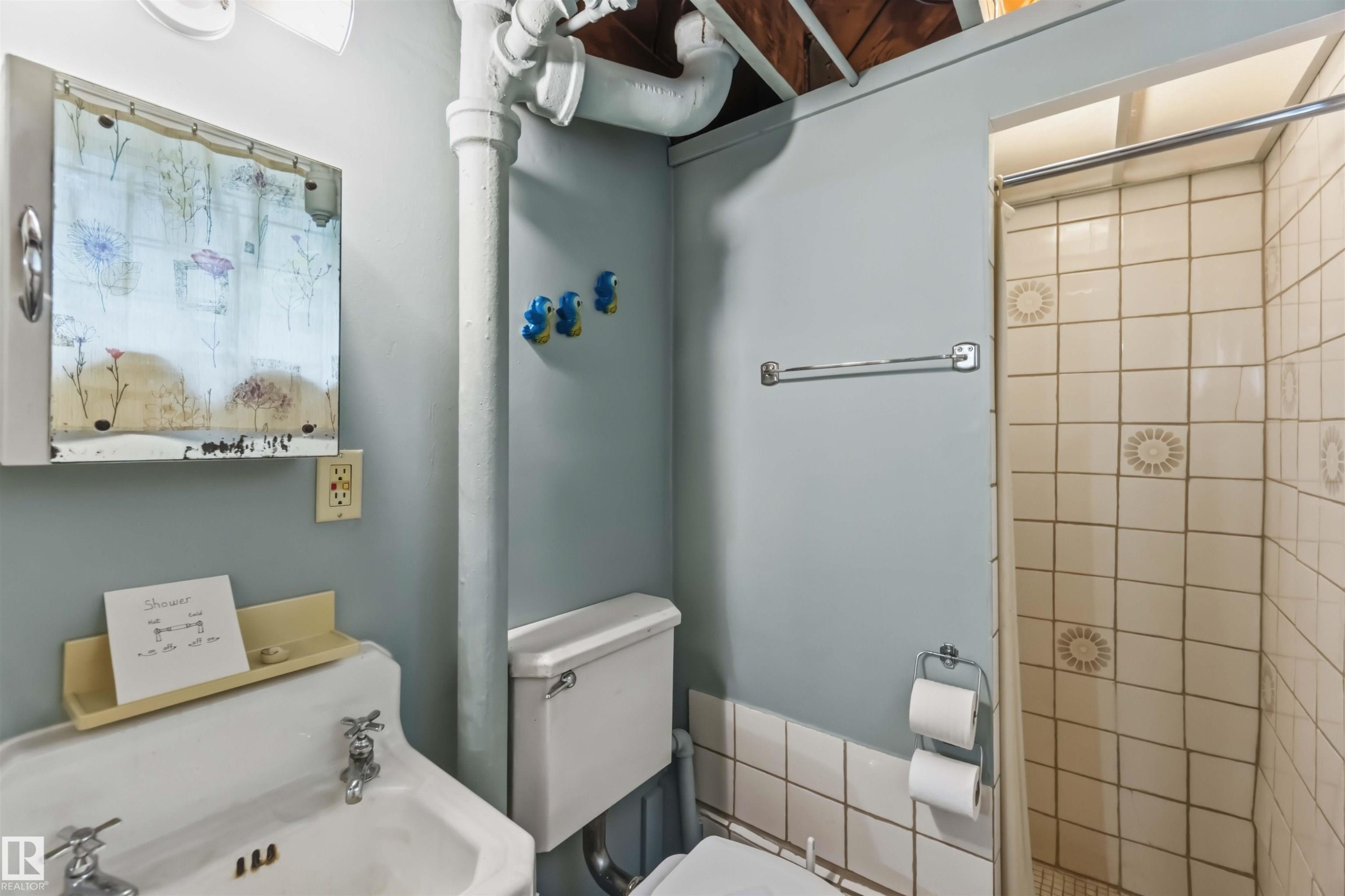 White pedestal sink with chrome faucets - 11710 94 Street Nw, Edmonton, AB - Indoor Photo Showing Bathroom