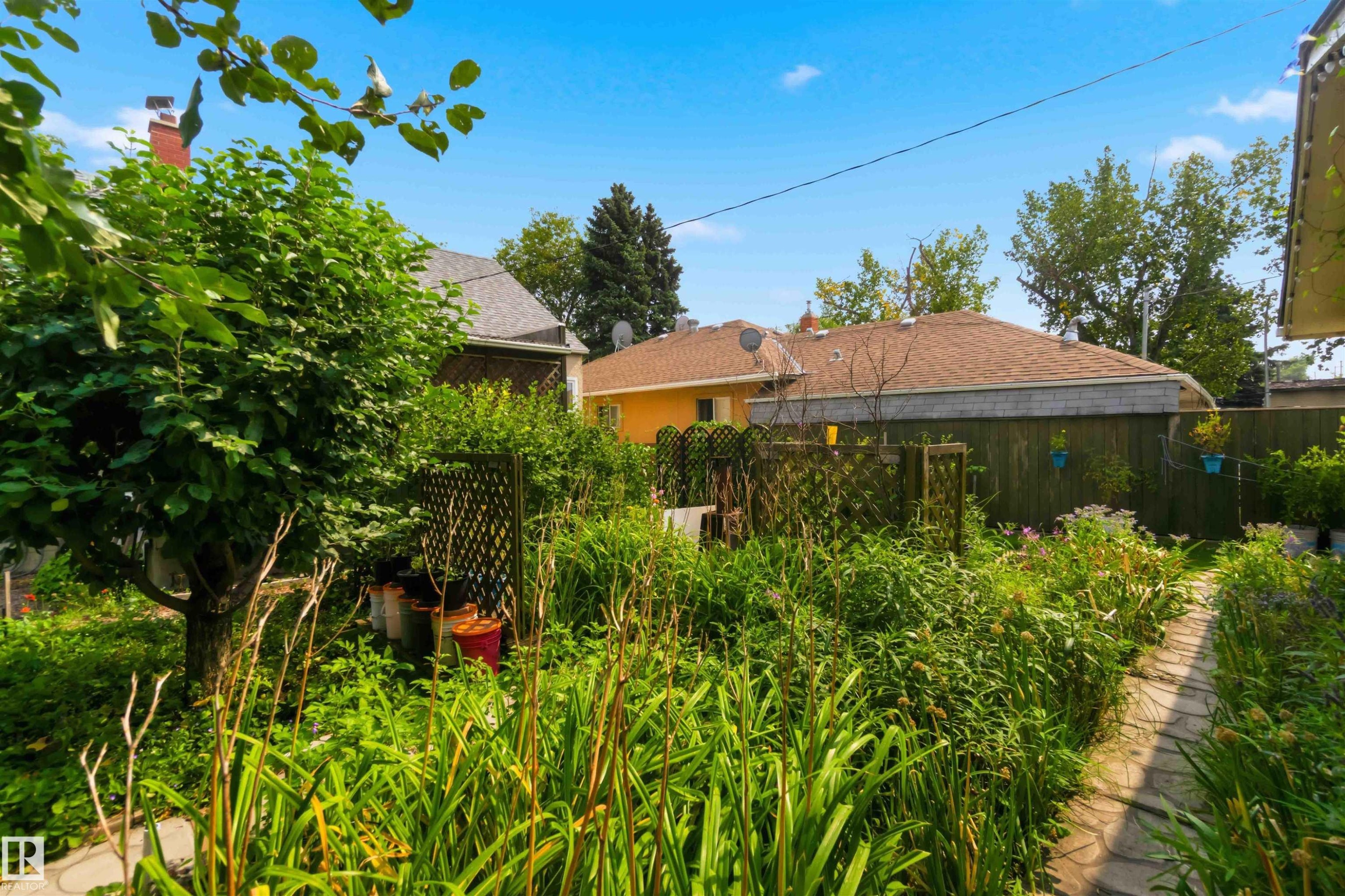 Manicured garden with a stone pathway and diverse plantings - 11710 94 Street Nw, Edmonton, AB - Outdoor