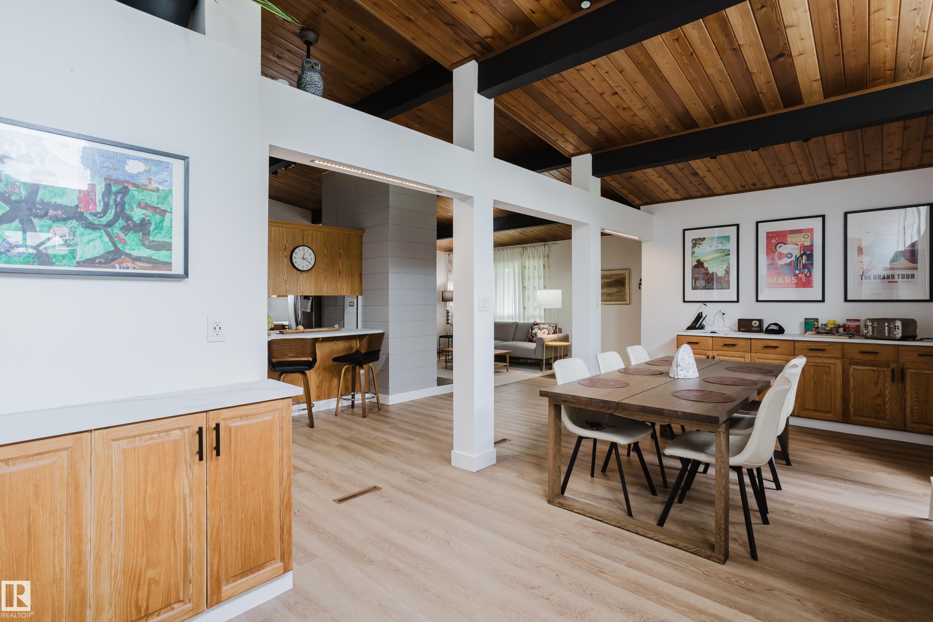 Vaulted wood-paneled ceiling with exposed beams, light wood-finish flooring, built-in wooden cabinetry, and a breakfast bar - 9059 52 Street Nw, Edmonton, AB - Indoor Photo Showing Dining Room
