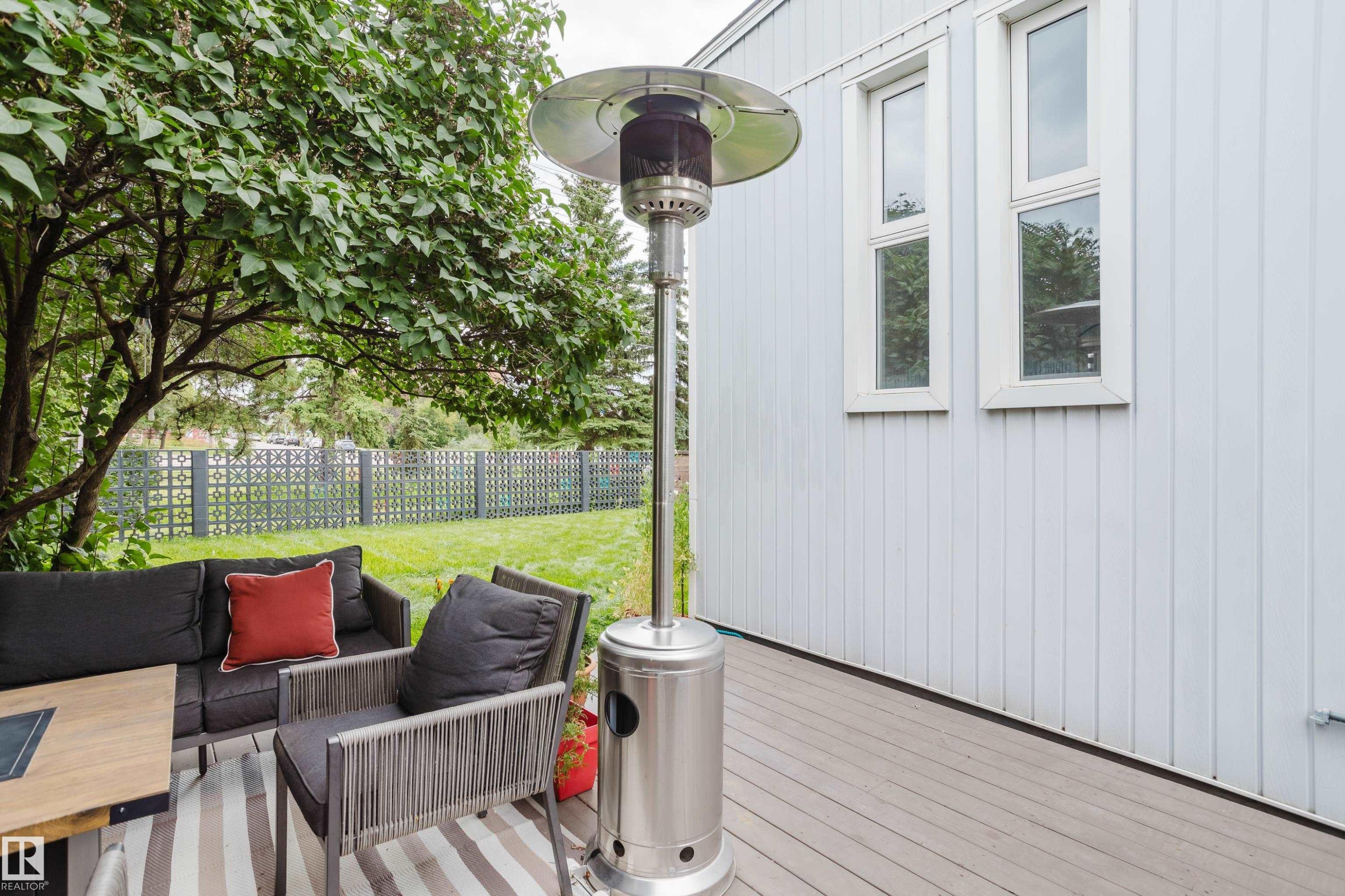 Expansive outdoor deck with a private yard, mature landscaping, and decorative fencing - 9059 52 Street Nw, Edmonton, AB - Outdoor With Exterior
