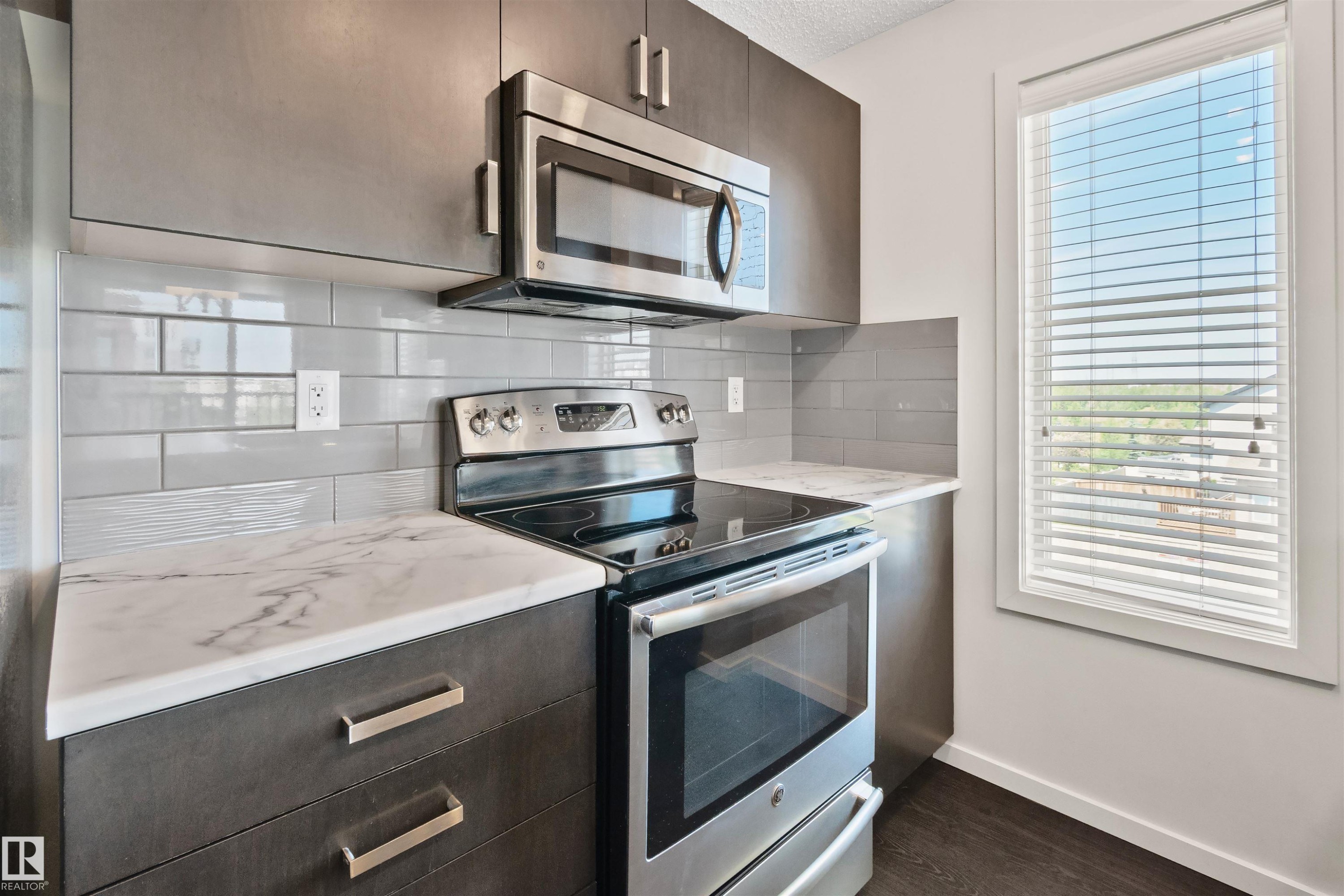 Stainless steel microwave and range - #318 5521 7 Av Sw Sw, Edmonton, AB - Indoor Photo Showing Kitchen With Stainless Steel Kitchen