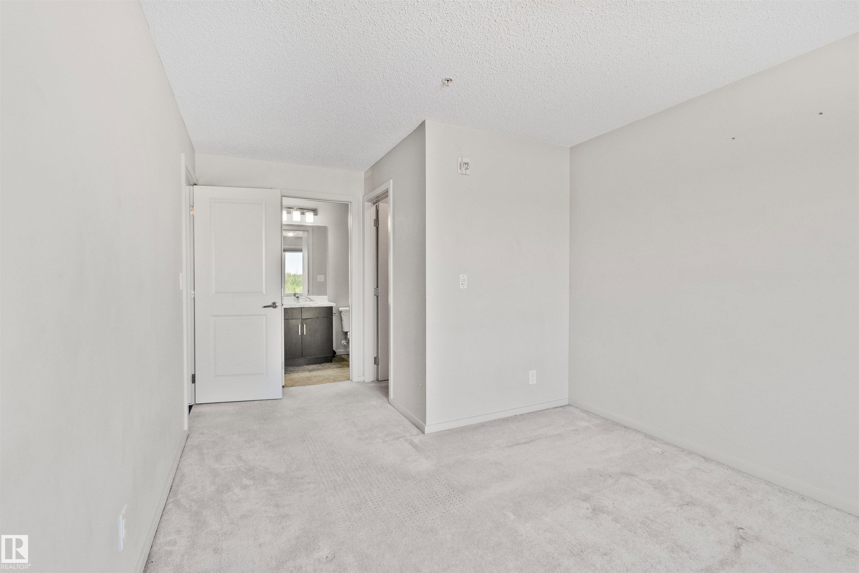 Neutral wall finishes and light-toned carpeting - #318 5521 7 Av Sw Sw, Edmonton, AB - Indoor Photo Showing Other Room