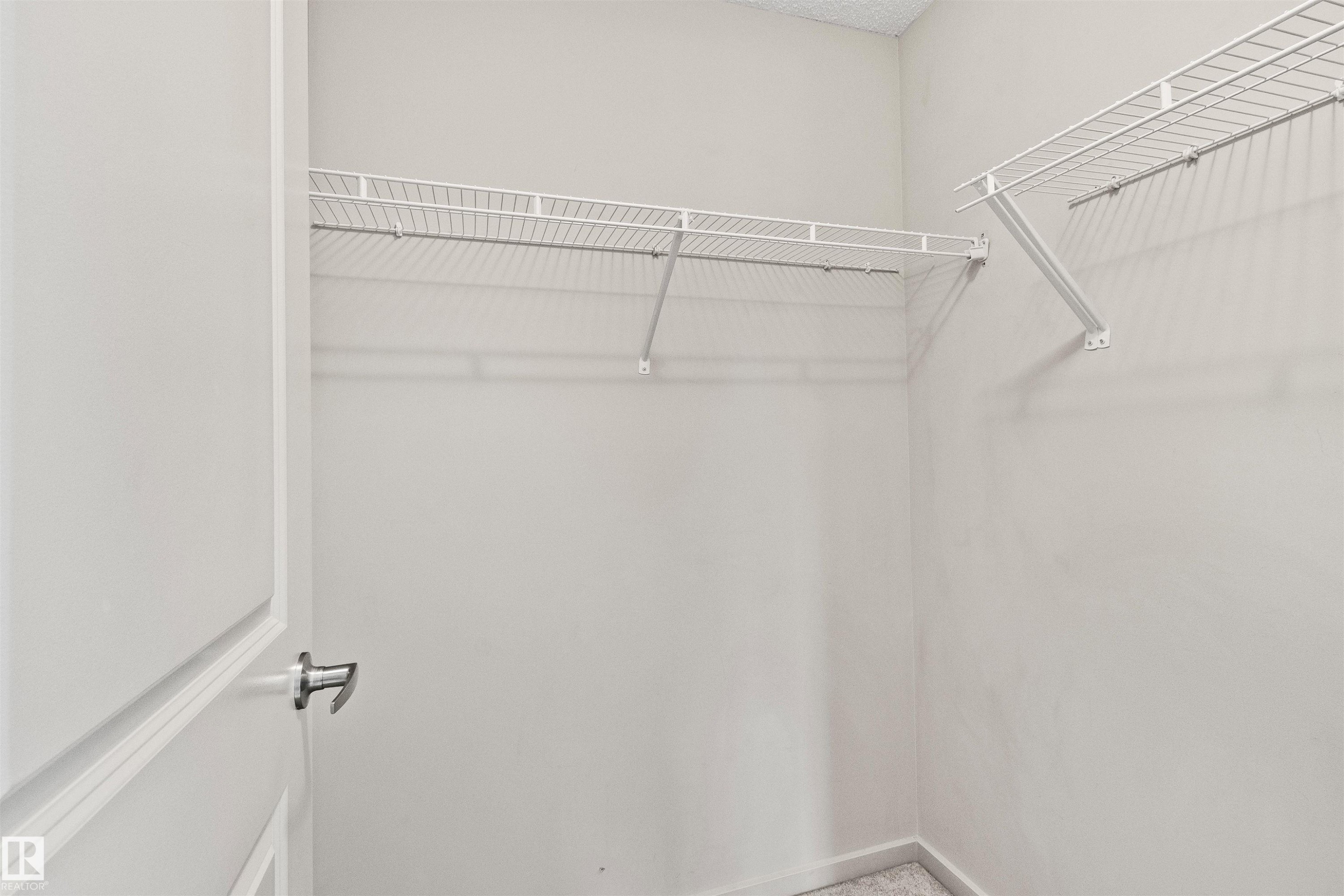 Walk-in closet featuring wire shelving and a metal door handle - #318 5521 7 Av Sw Sw, Edmonton, AB - Indoor With Storage