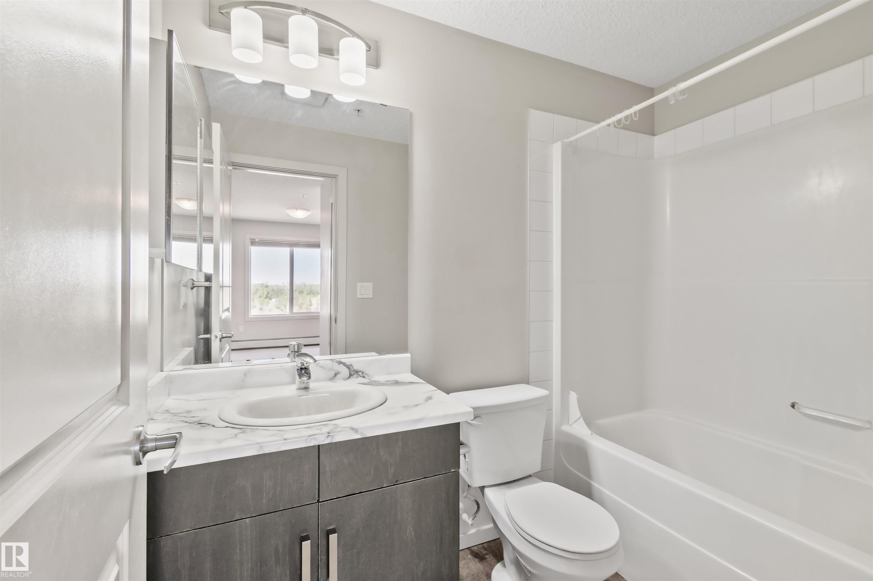 Vanity with a polished chrome faucet and a white oval sink - #318 5521 7 Av Sw Sw, Edmonton, AB - Indoor Photo Showing Bathroom