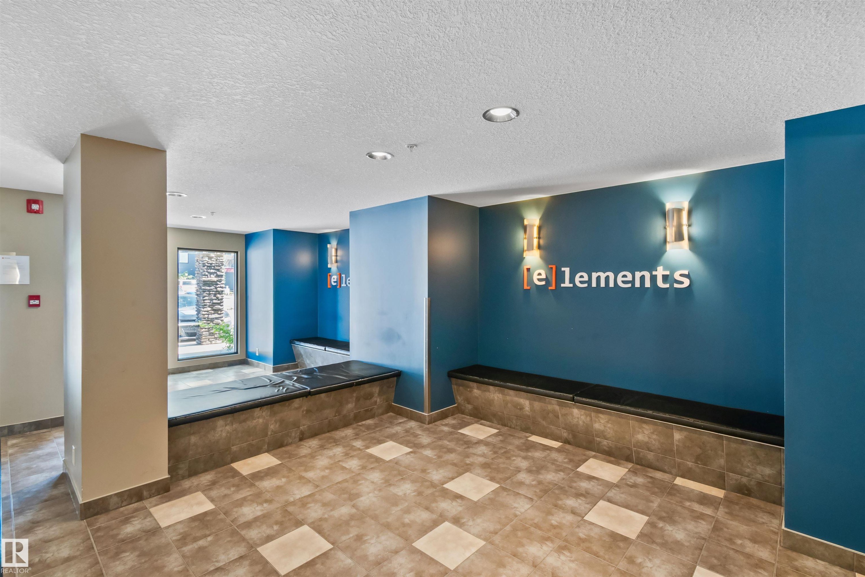 Tiled flooring with a geometric pattern, built-in benches, recessed lighting, and wall-mounted sconces - #318 5521 7 Av Sw Sw, Edmonton, AB - Indoor Photo Showing Other Room