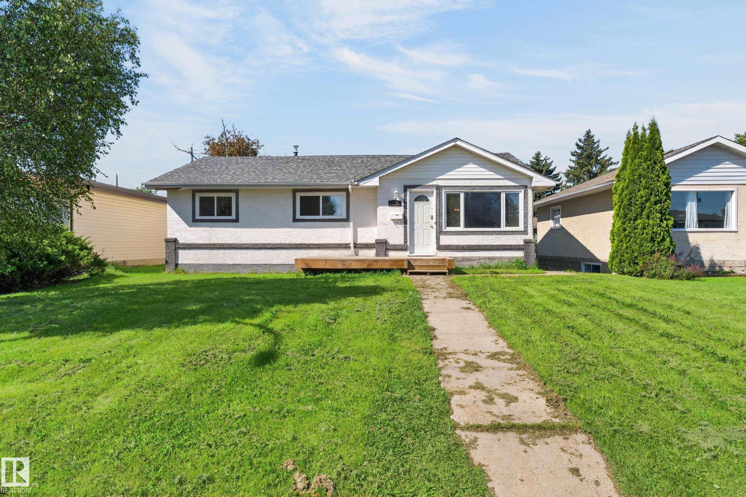 Single-story residence featuring a gabled roofline, white siding, and dark trim - 13214 123 Street Nw, Edmonton, AB