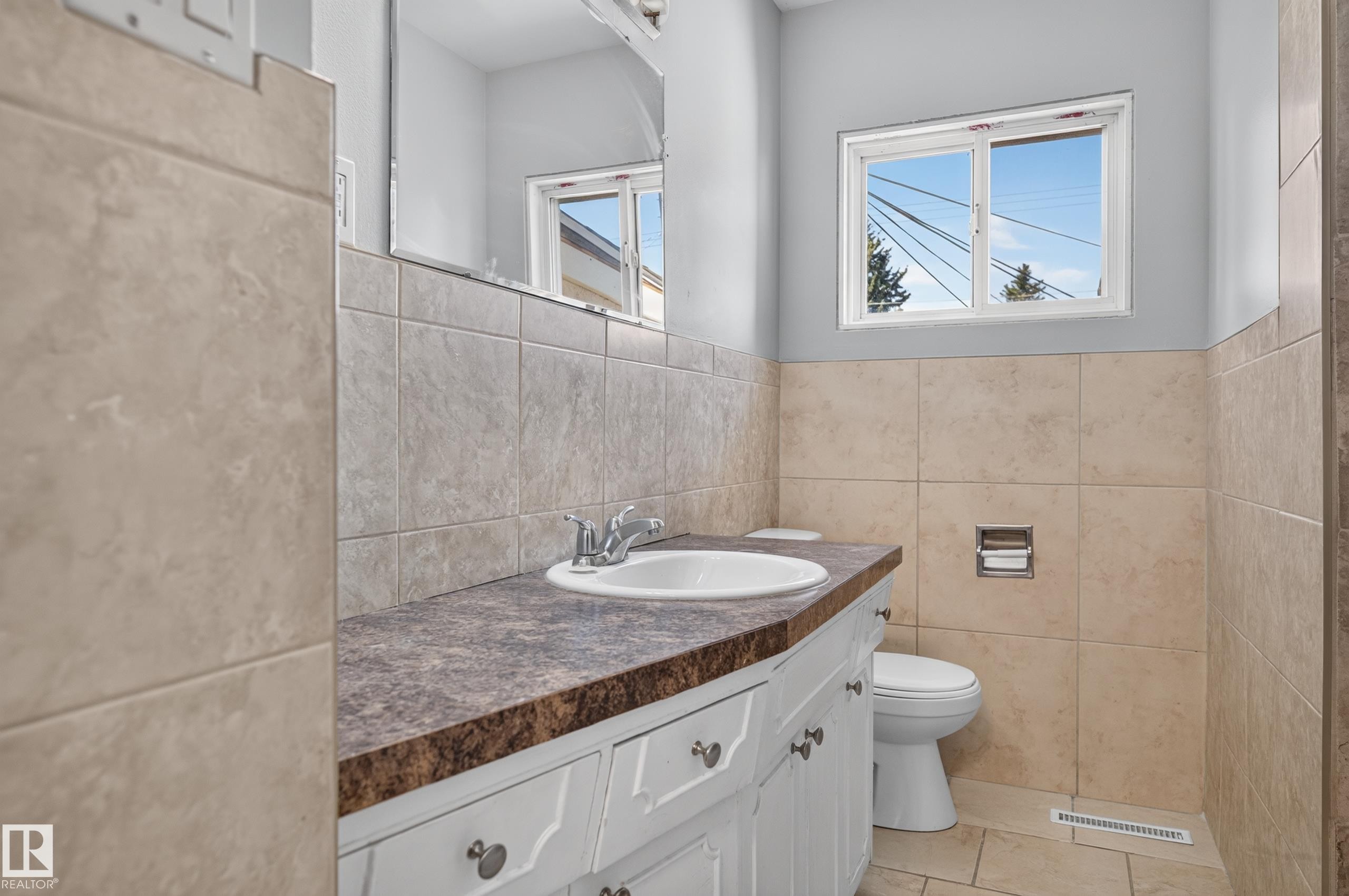 White vanity with dual-knob hardware, integrated sink, and patterned countertop - 13214 123 Street Nw, Edmonton, AB