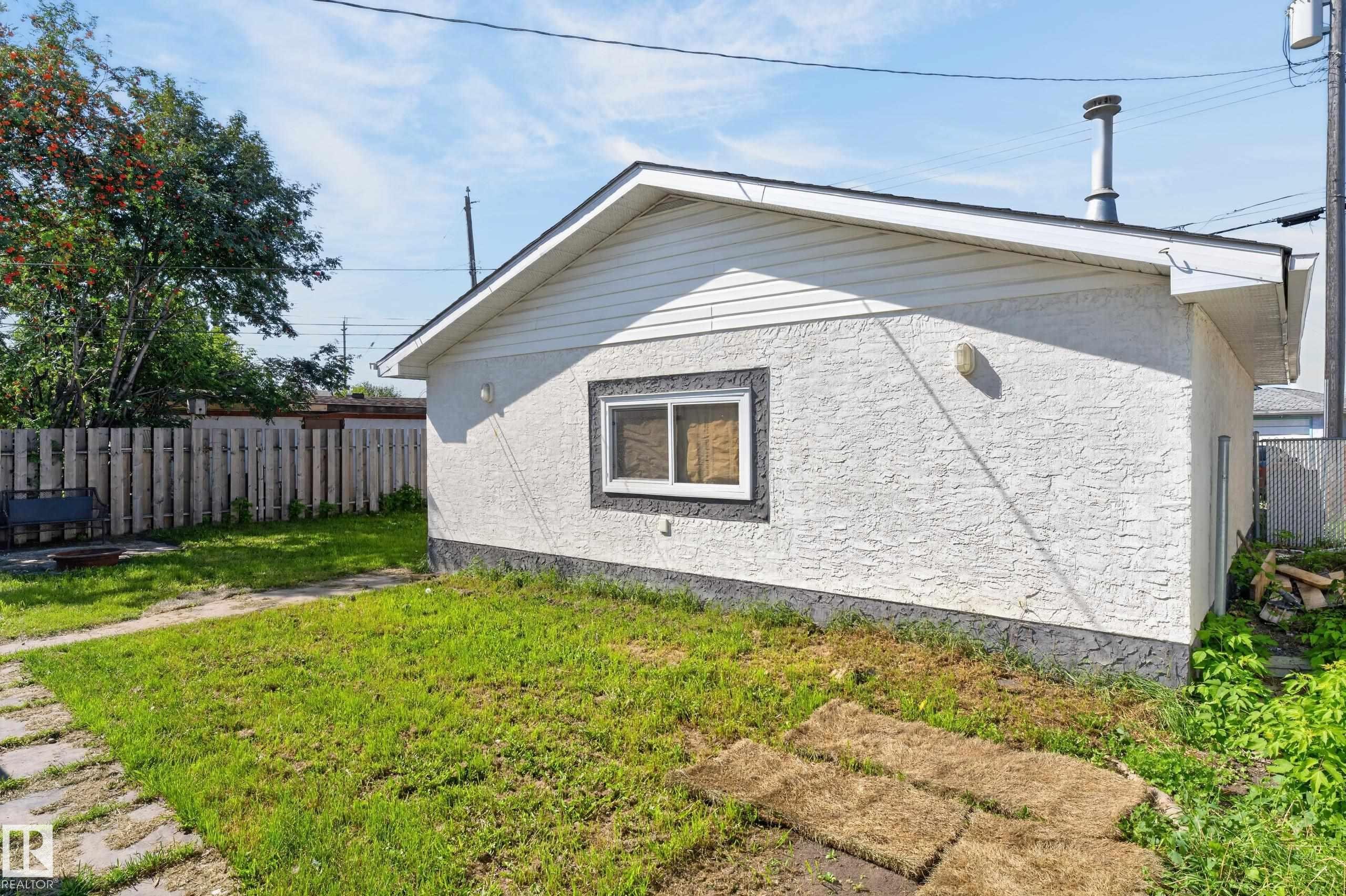 Detached structure with stucco exterior, a single window with dark trim, and a shingled roof - 13214 123 Street Nw, Edmonton, AB