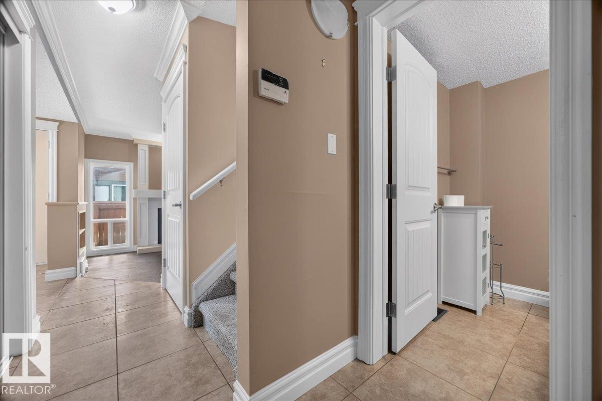 Tiled flooring leading to an open doorway with a white interior door - #47 3812 20 Av Nw, Edmonton, AB
