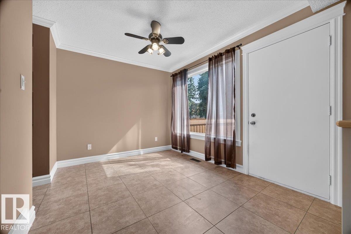 Neutral-toned wall paint, crown molding, and ceiling fan with integrated lighting - #47 3812 20 Av Nw, Edmonton, AB