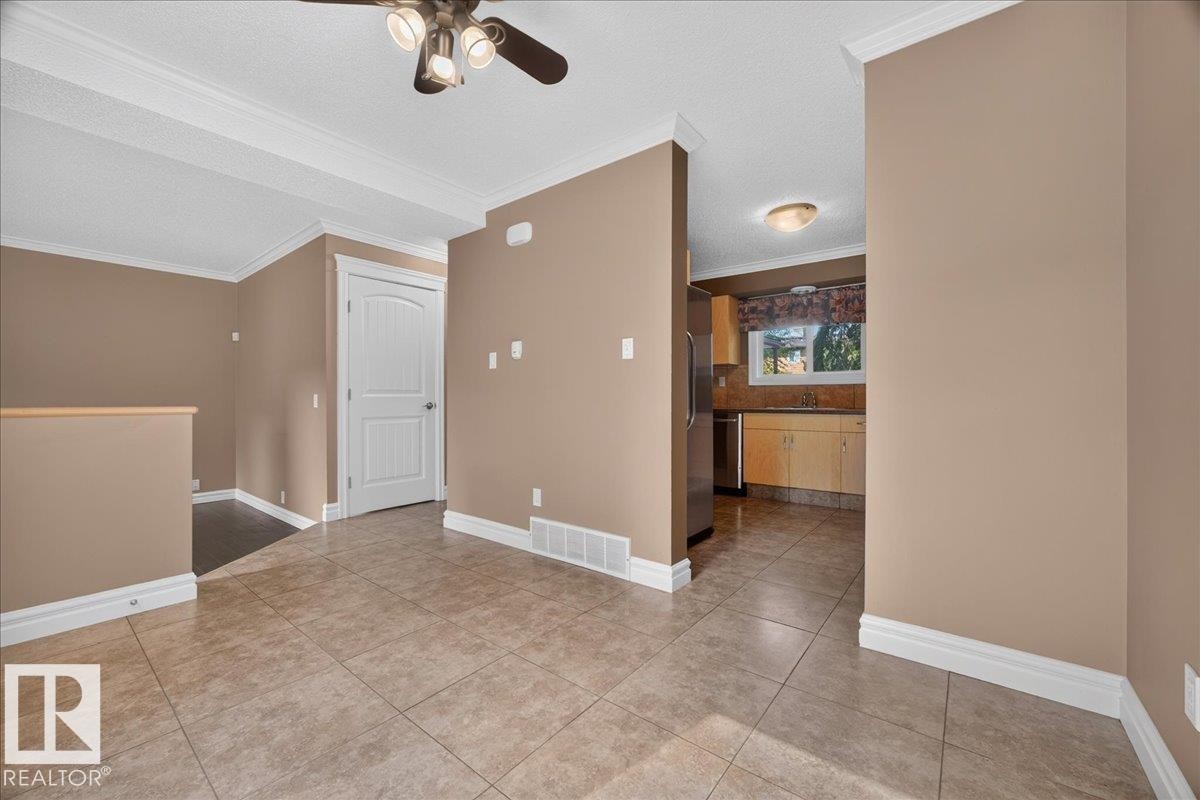 Tiled flooring throughout, crown molding accents, and a built-in ceiling fan with lighting - #47 3812 20 Av Nw, Edmonton, AB