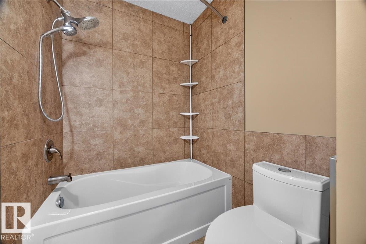 White tub with brushed chrome fixtures and a handheld showerhead - #47 3812 20 Av Nw, Edmonton, AB
