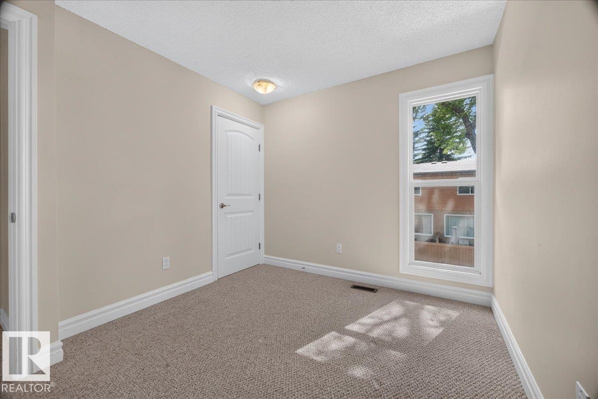 Neutral wall color, wall-to-wall carpeting, white trim, white paneled door, and a single window - #47 3812 20 Av Nw, Edmonton, AB