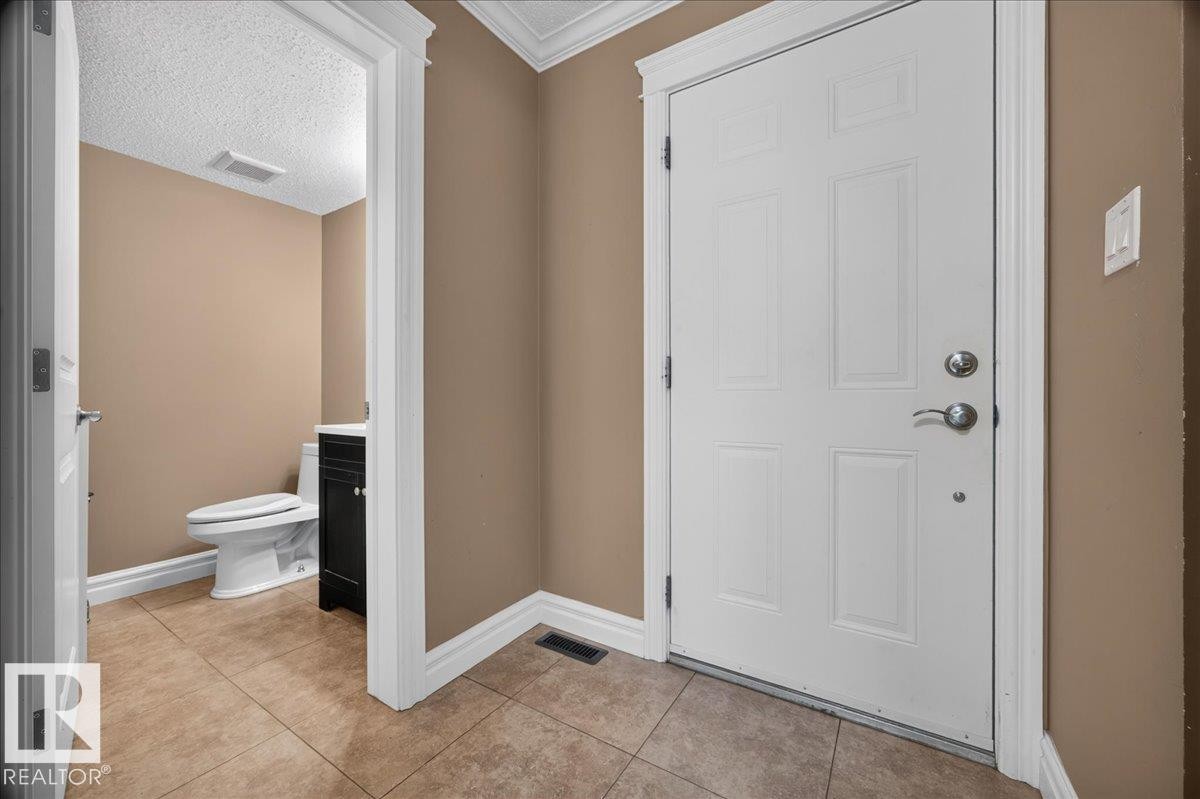 Tile flooring, white paneled door, and crown molding accents - #47 3812 20 Av Nw, Edmonton, AB