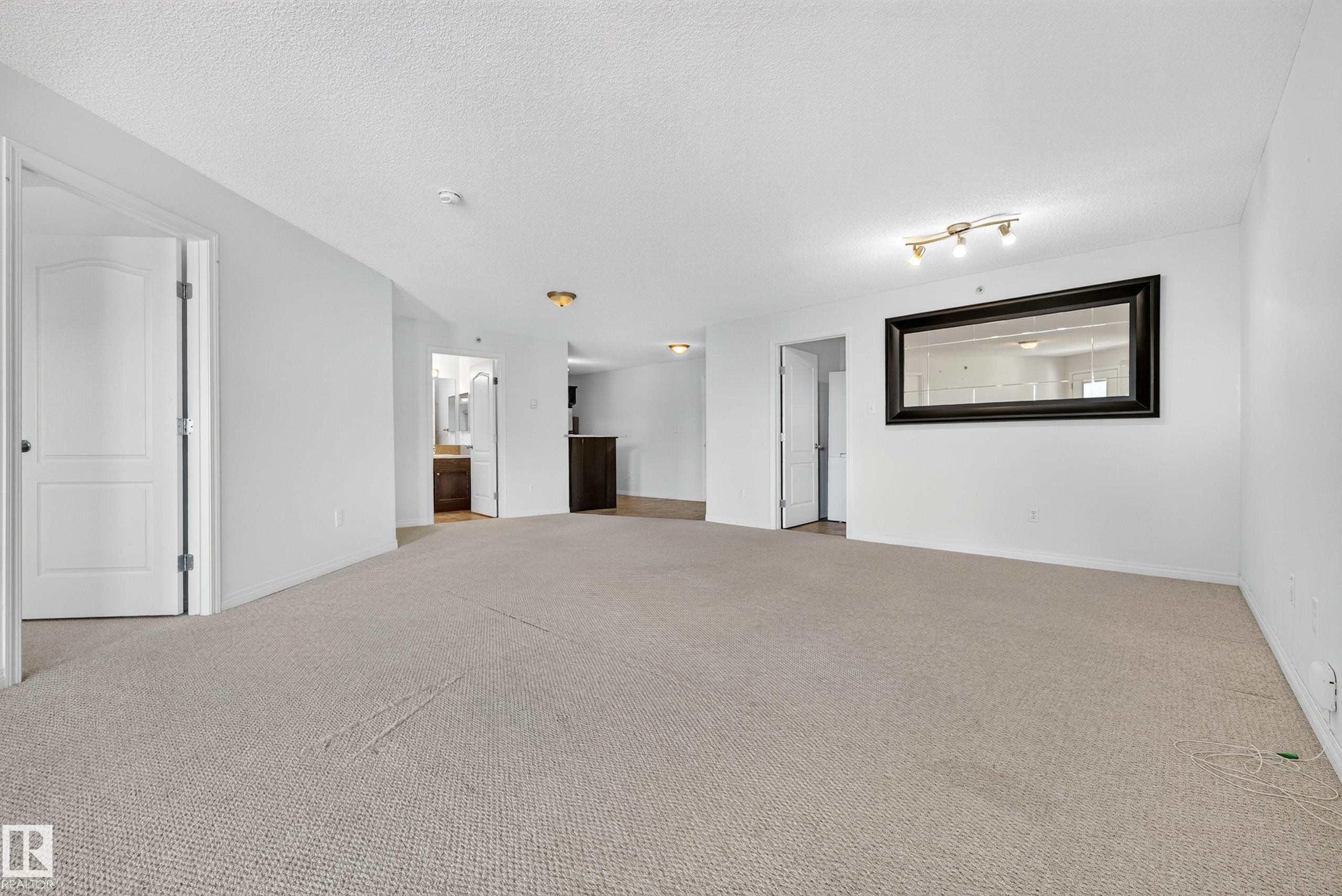 Neutral-toned carpet flooring, white walls, and track lighting - #6430 7331 South Terwillegar Dr Nw, Edmonton, AB