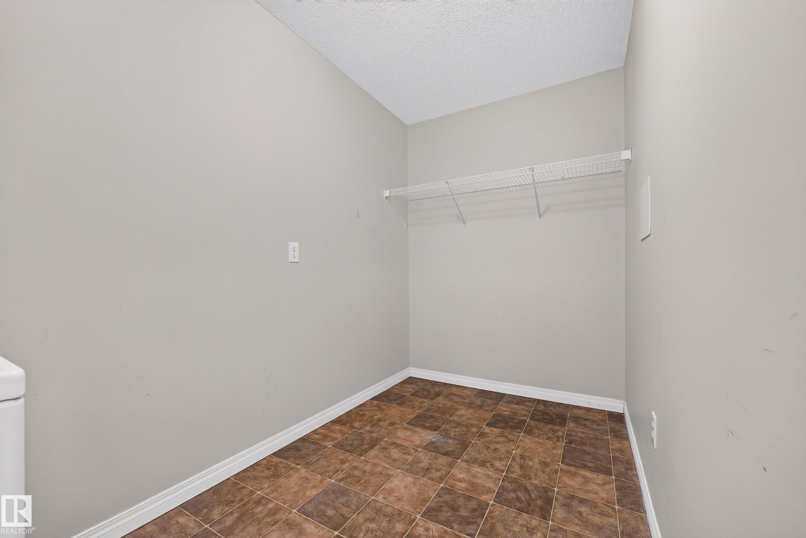 Utility room with tiled flooring and a wall-mounted wire shelf - #6430 7331 South Terwillegar Dr Nw, Edmonton, AB