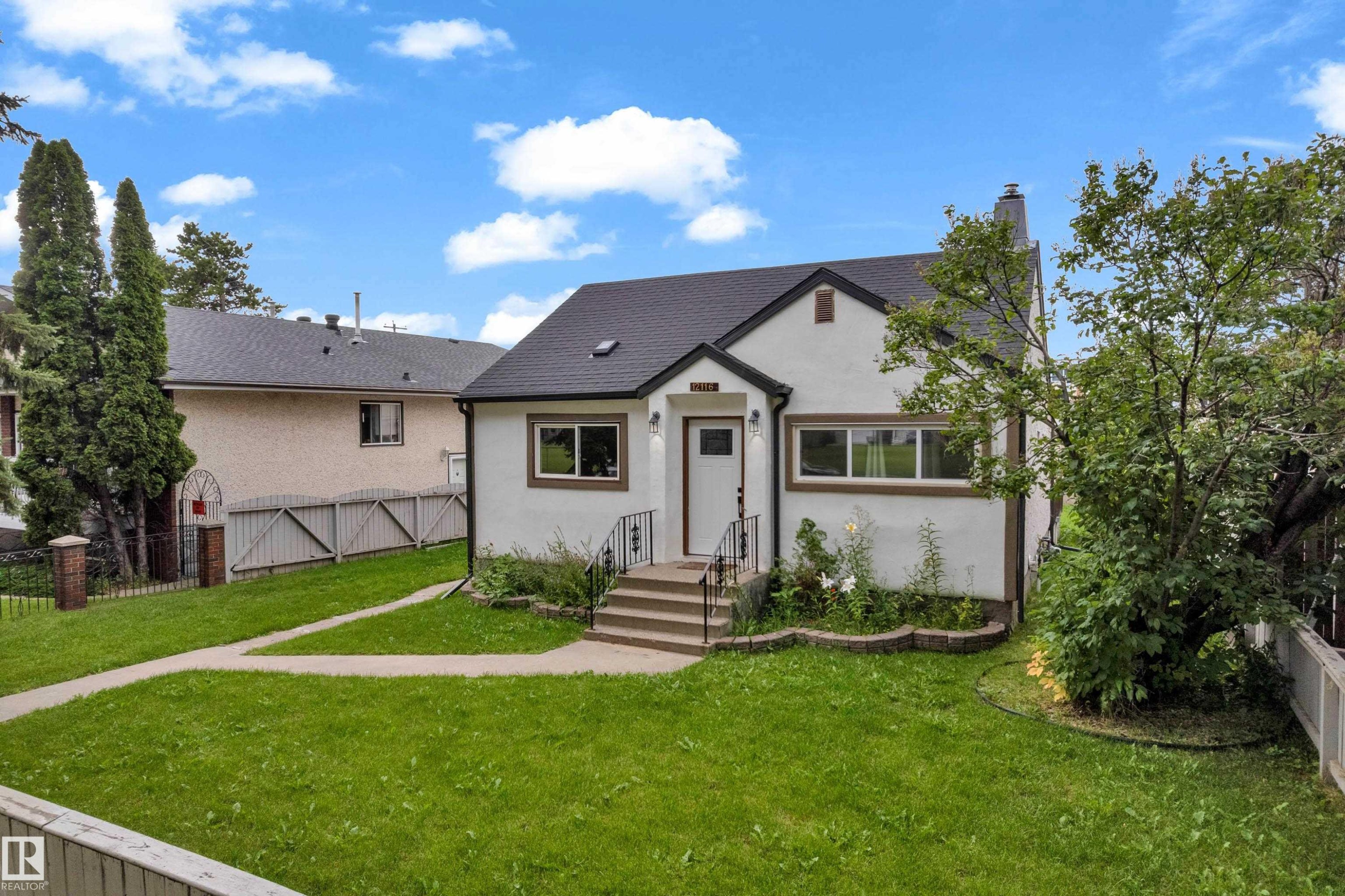 White stucco exterior with a dark shingle roof - 12116 81 Street Nw, Edmonton, AB