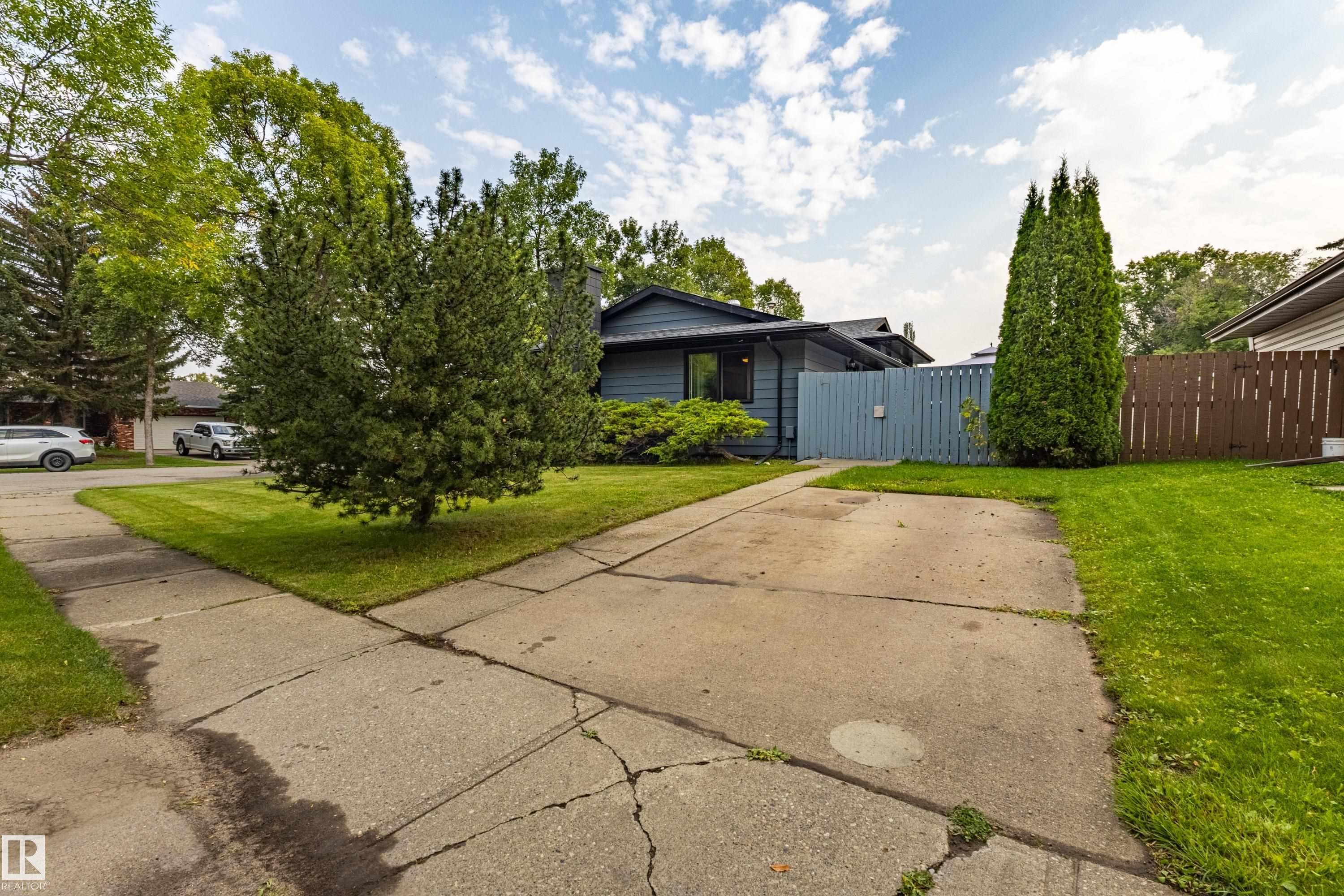 Charming single-story home with a spacious concrete driveway and mature landscaping - 14 Brunswick Crescent, St. Albert, AB