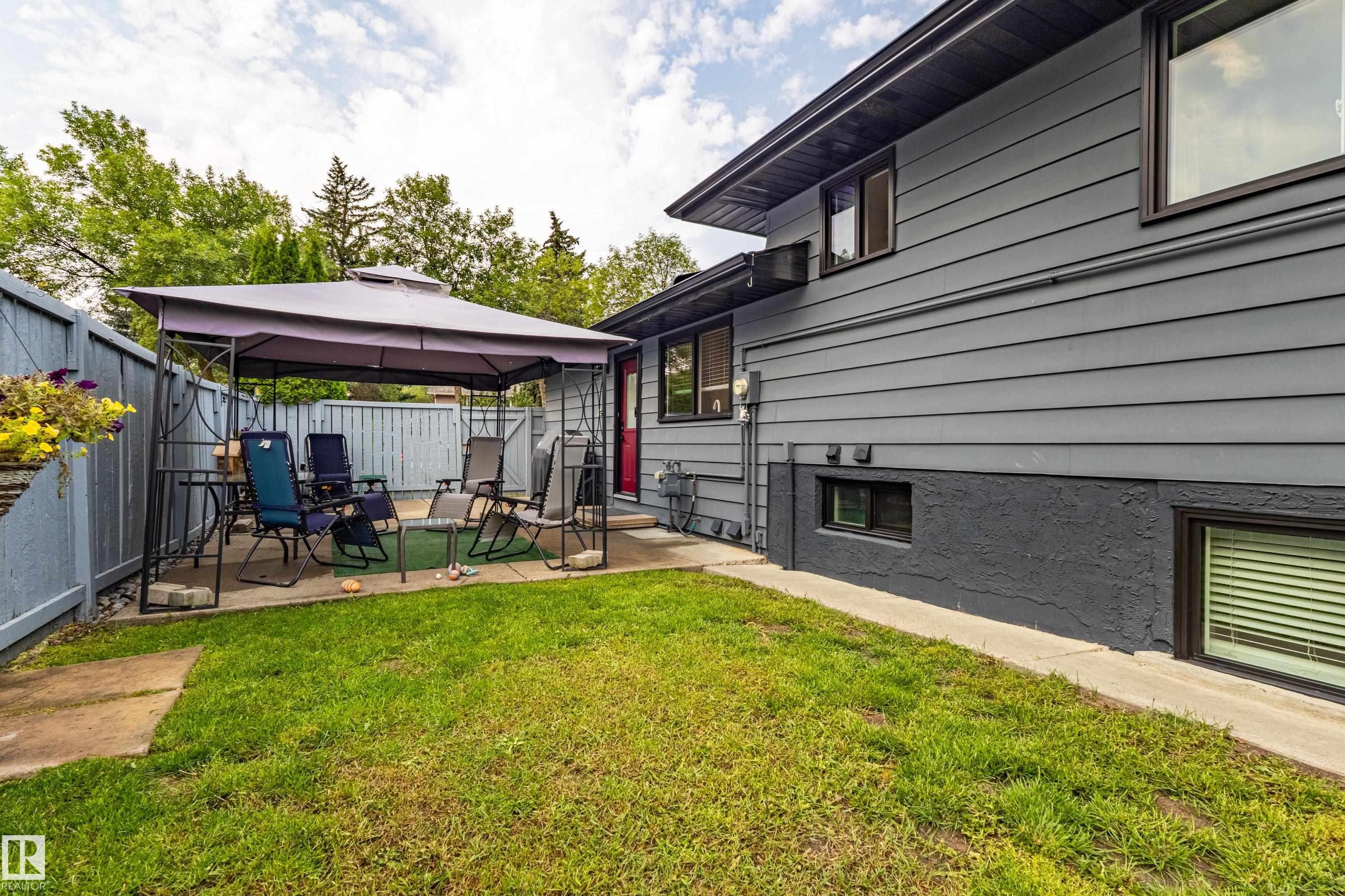 Exterior featuring horizontal siding, a fenced yard, and an outdoor patio space - 14 Brunswick Crescent, St. Albert, AB