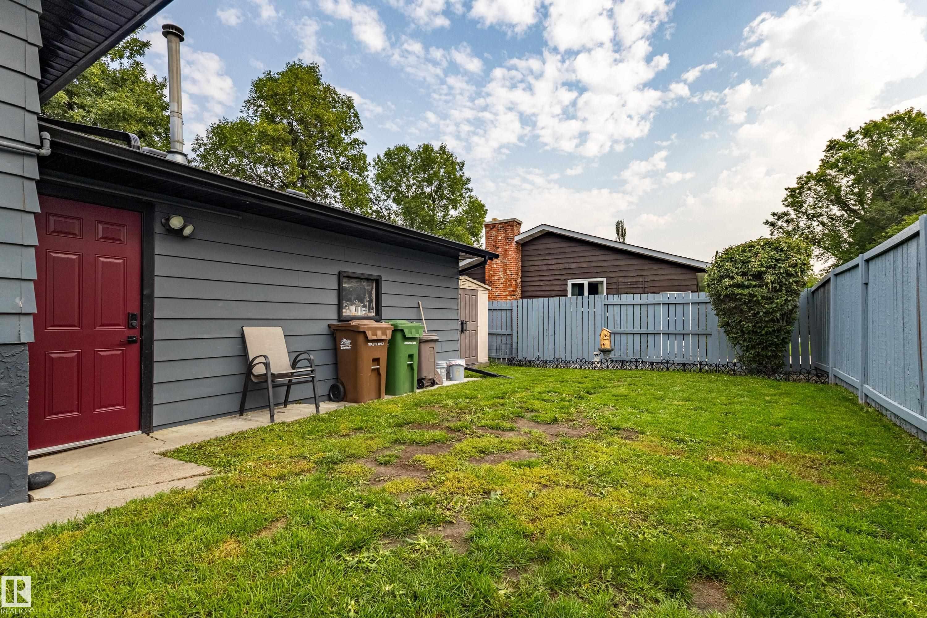 Spacious backyard with mature landscaping and lush lawn, bordered by secure fencing - 14 Brunswick Crescent, St. Albert, AB