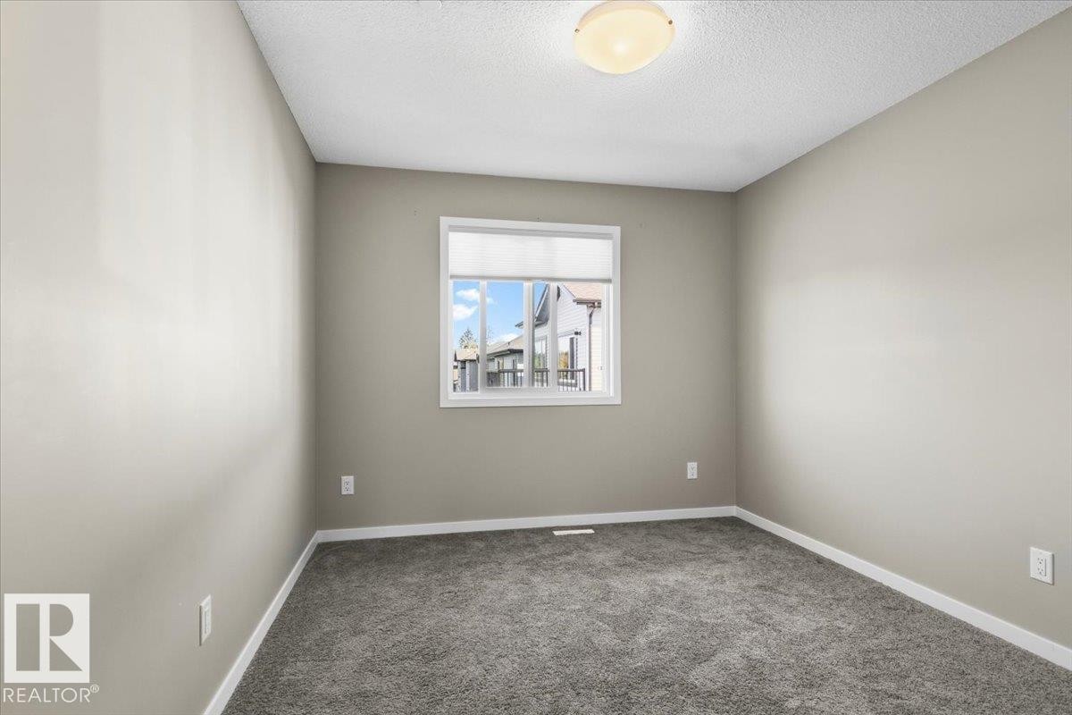 Soft gray carpet flooring, neutral painted walls, and a white-framed window - 1807 Westerra Loop, Stony Plain, AB