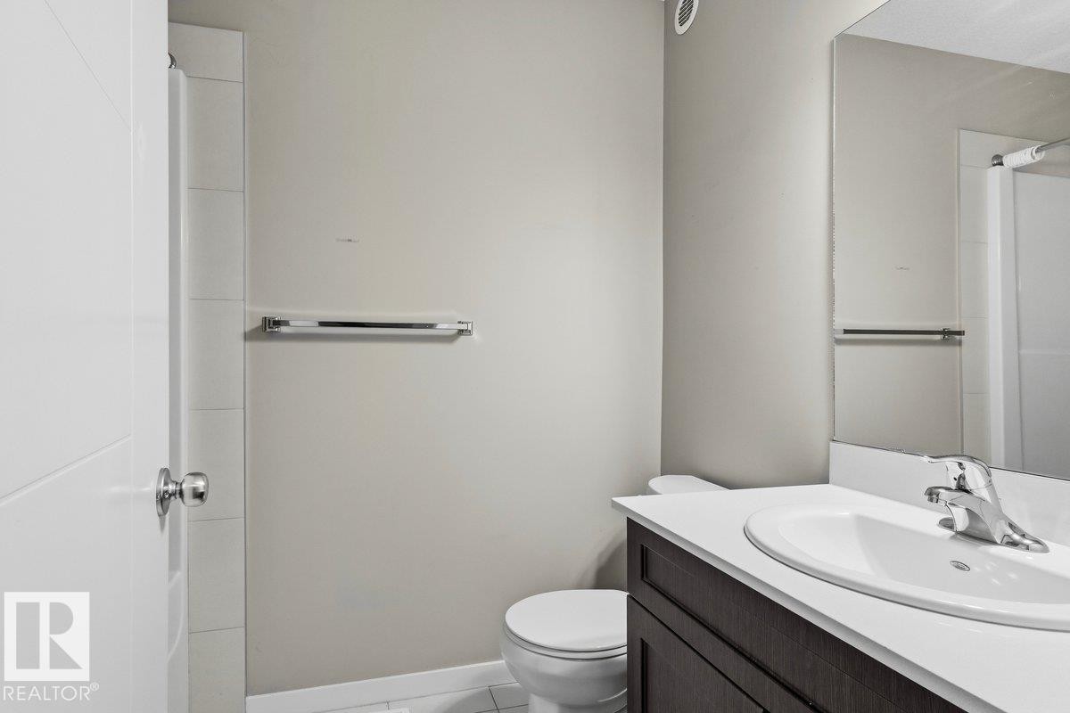 White vanity countertop with an integrated oval sink and chrome faucet - 1807 Westerra Loop, Stony Plain, AB