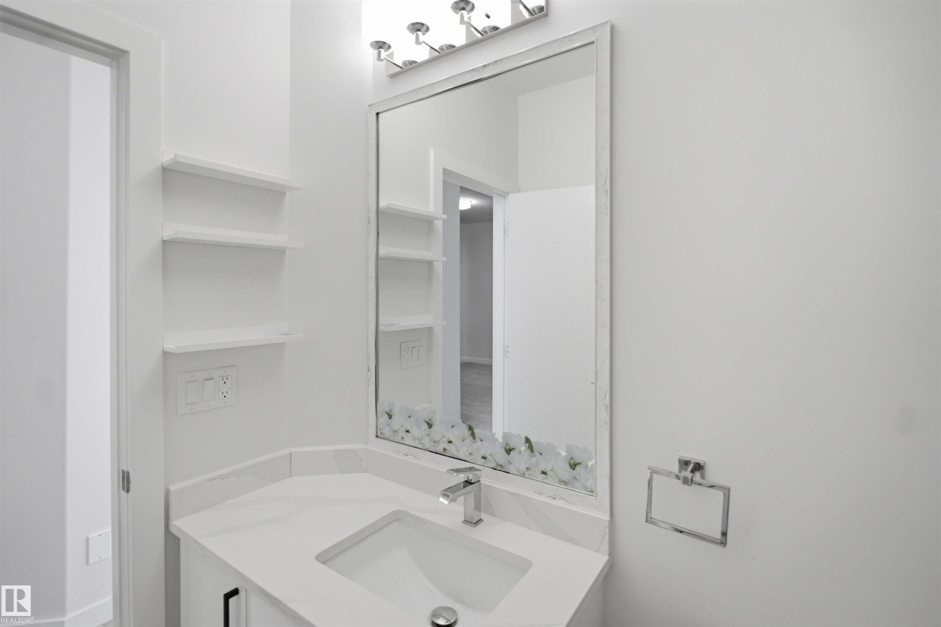 Vanity with white countertop, integrated sink, chrome faucet, and mirrored wall cabinet - 2027 13 Avenue Nw, Edmonton, AB