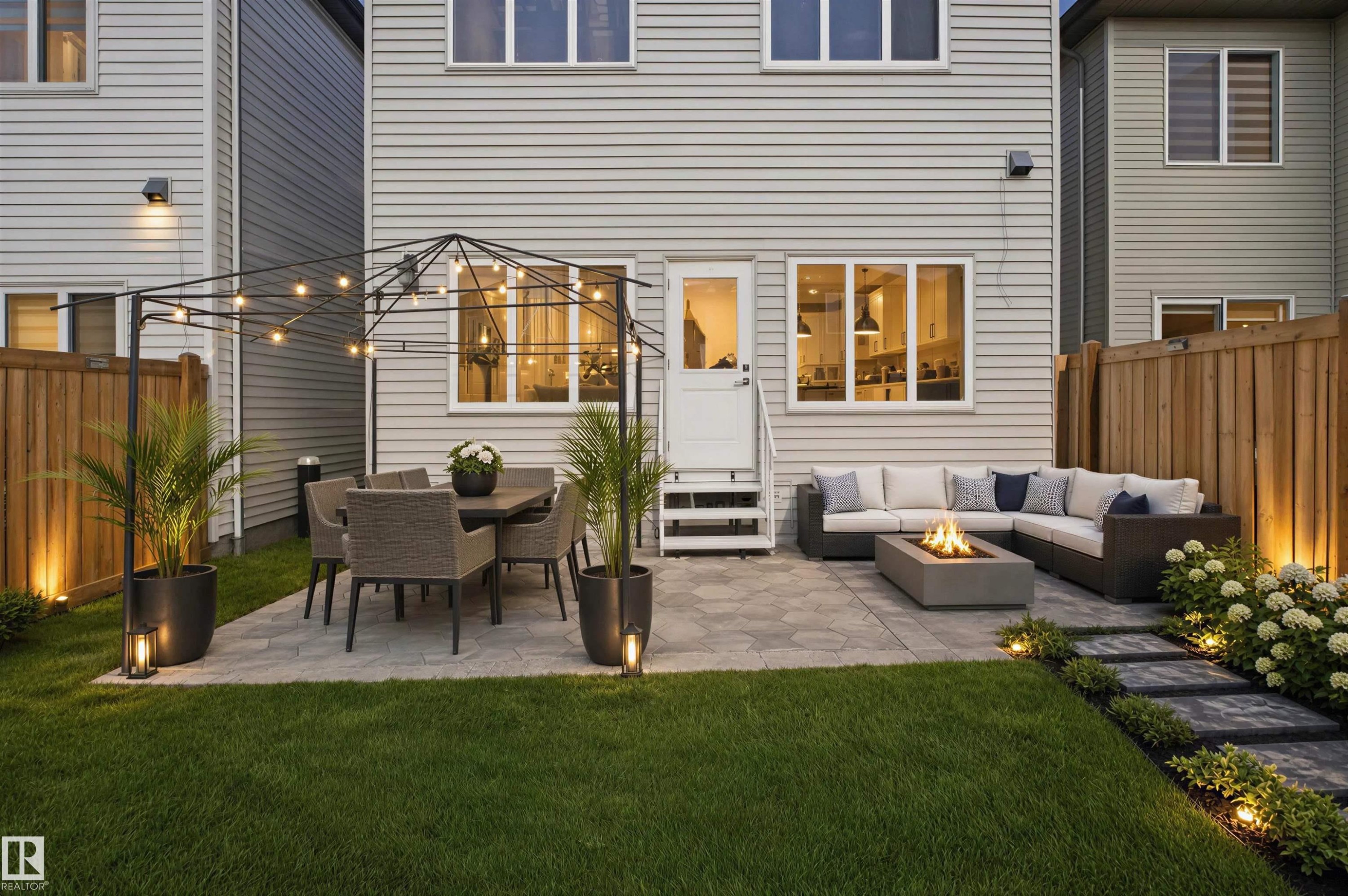 Paved patio area, manicured lawn, stone pathway, wood fencing, and exterior lighting - 2027 13 Avenue Nw, Edmonton, AB