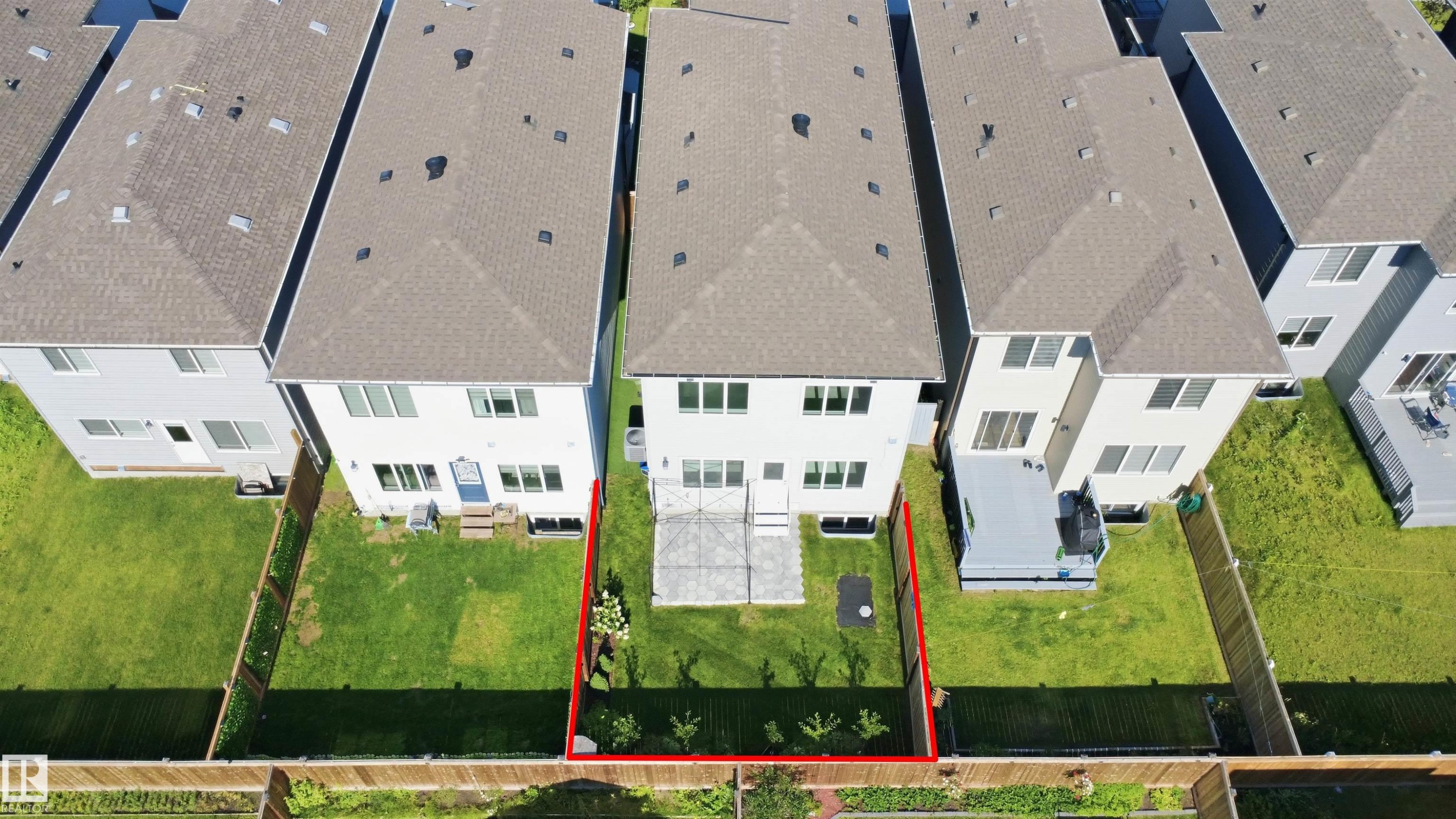 Expansive green space featuring a concrete patio, wood fencing, and mature landscaping - 2027 13 Avenue Nw, Edmonton, AB